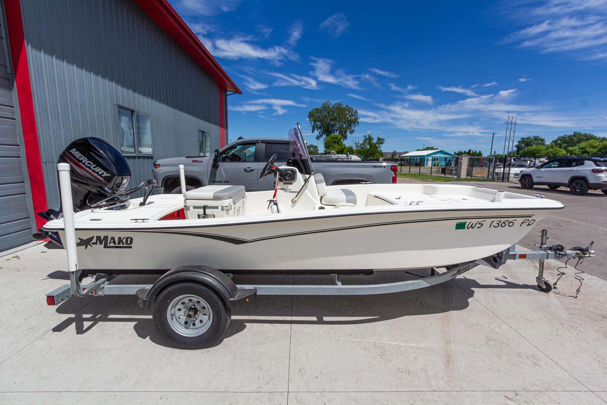 2020 Mako Pro Skiff 15 CC boat on trailer, parked outdoors under clear blue sky.