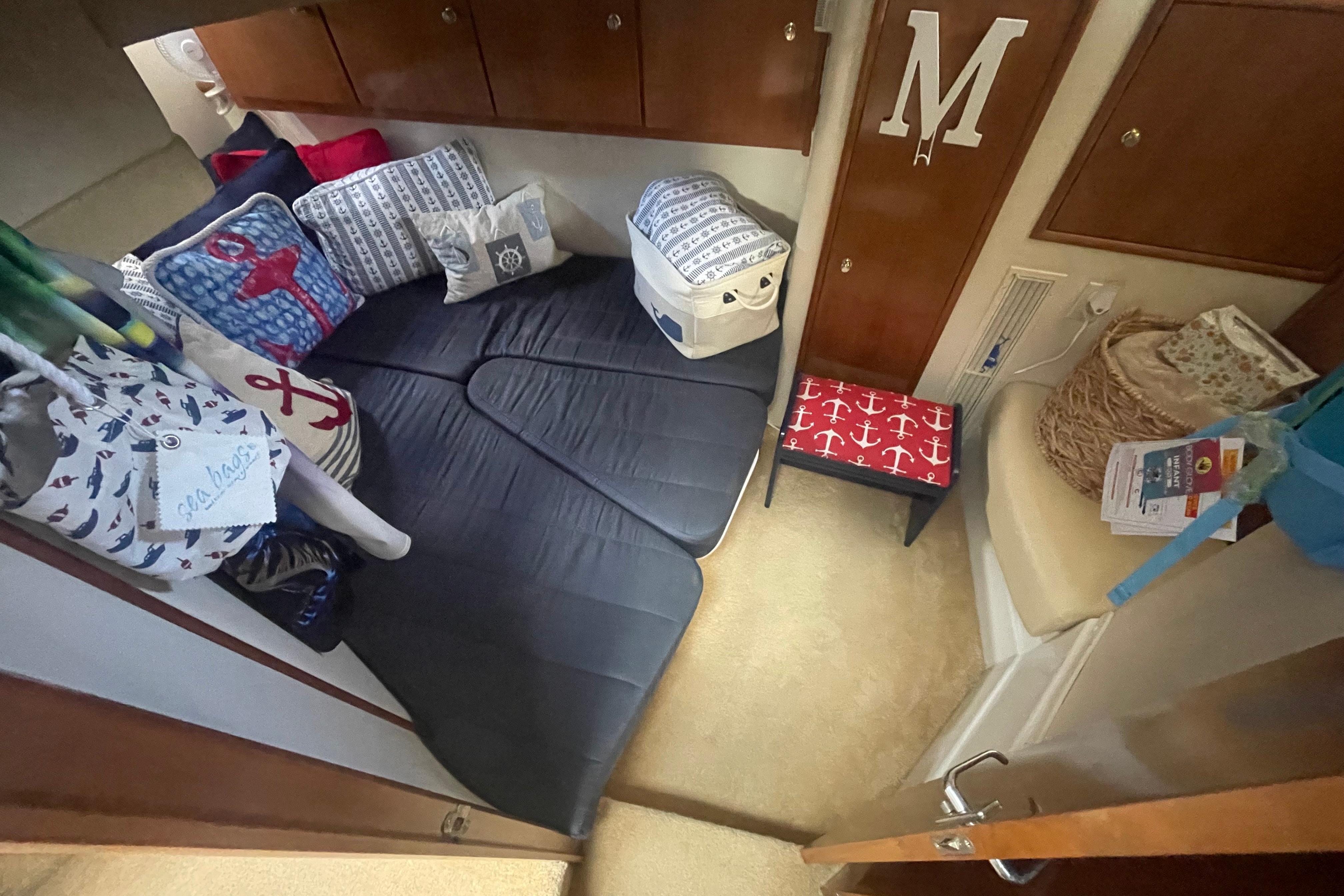 Cozy interior of 2002 Carver 410 Sport Sedan with nautical-themed decor and cushions.
