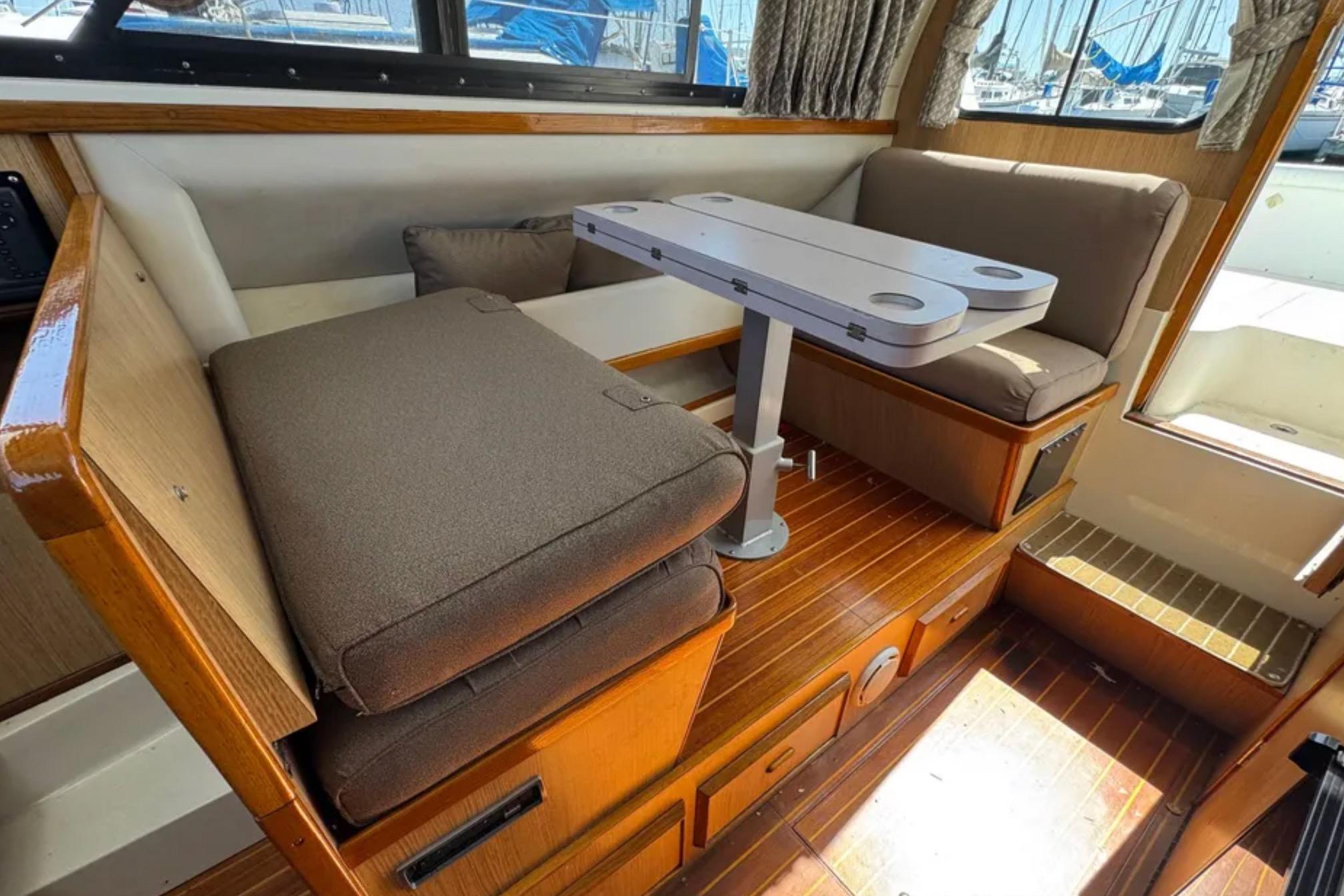 Interior of a 1988 Bertram 28 Sport Fisherman with cushioned seating and a compact table.