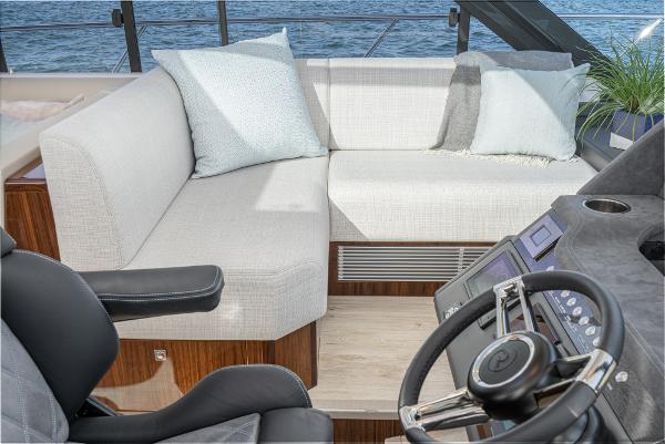 Interior of 2021 Riviera 5400 Sport Yacht with plush seating and modern helm.