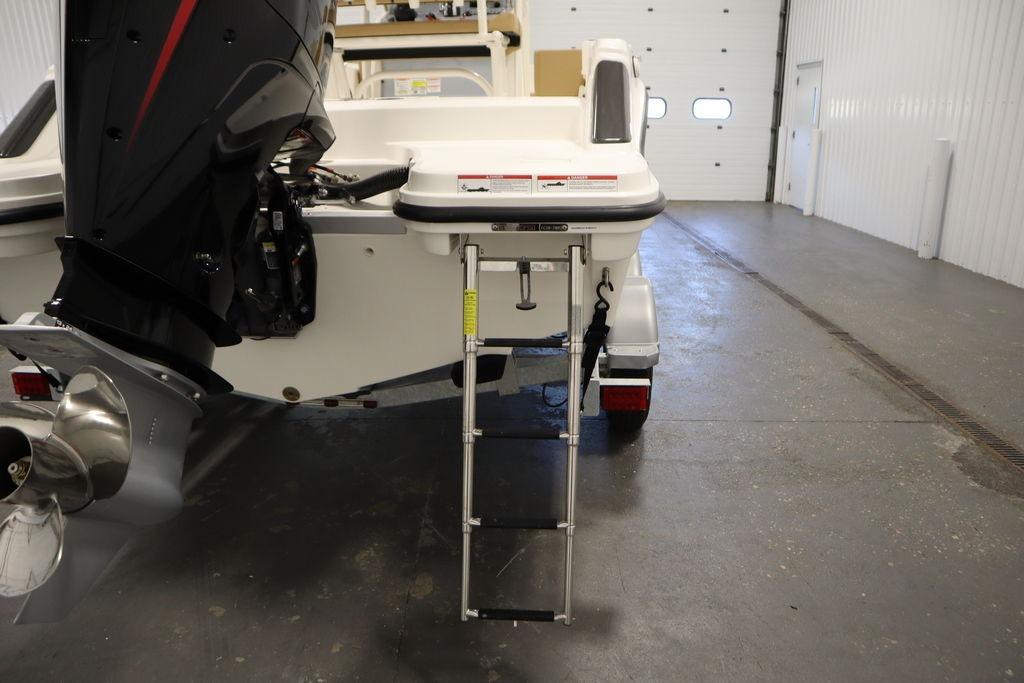 2026 Bayliner Trophy T20CC boat with outboard motor and ladder in a garage.