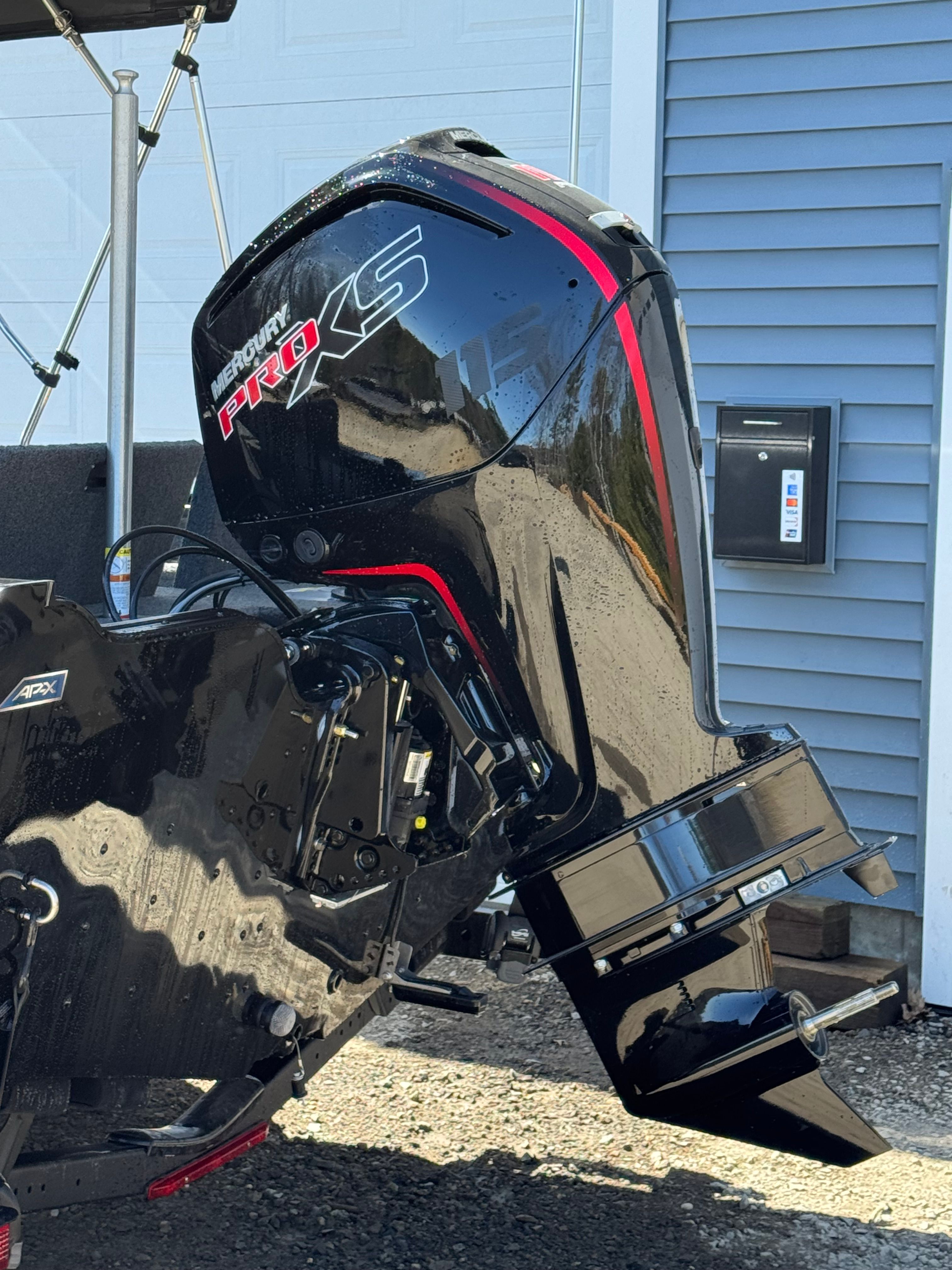 A Mercury Pro XS outboard motor on a boat resting on a trailer.