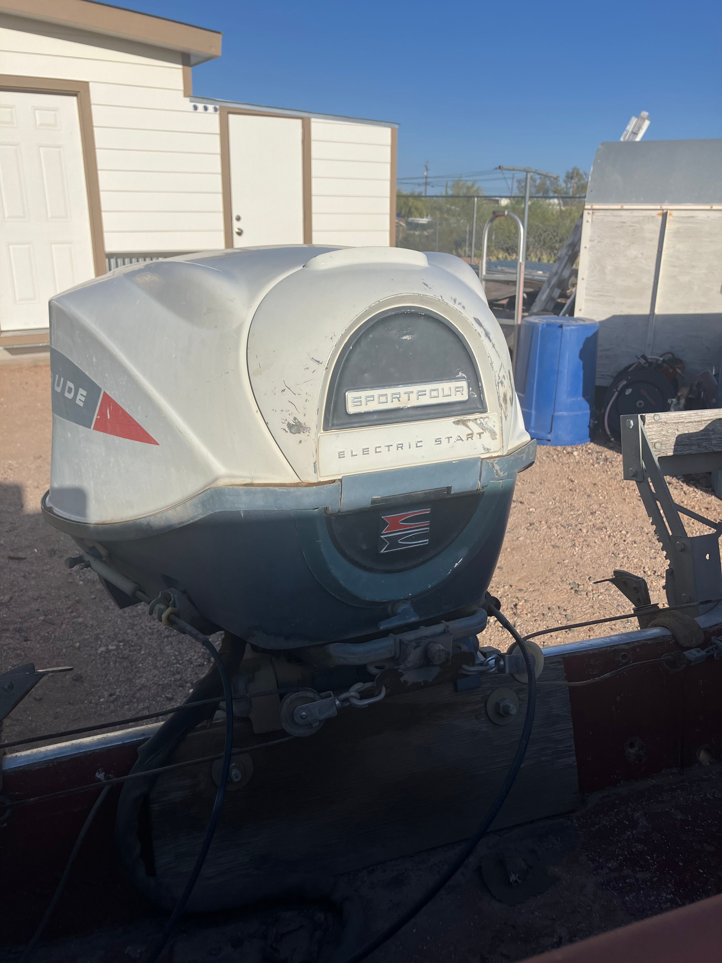 An outboard motor labeled "Sportfour Electric Start" is mounted on a boat.