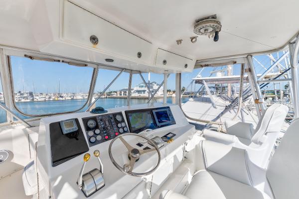 Interior helm of 1999 Viking 47 Convertible yacht with navigation equipment and marina view.