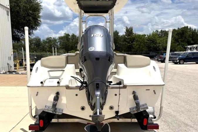 2023 Key West 203 FS boat with powerful outboard motor, parked outdoors.