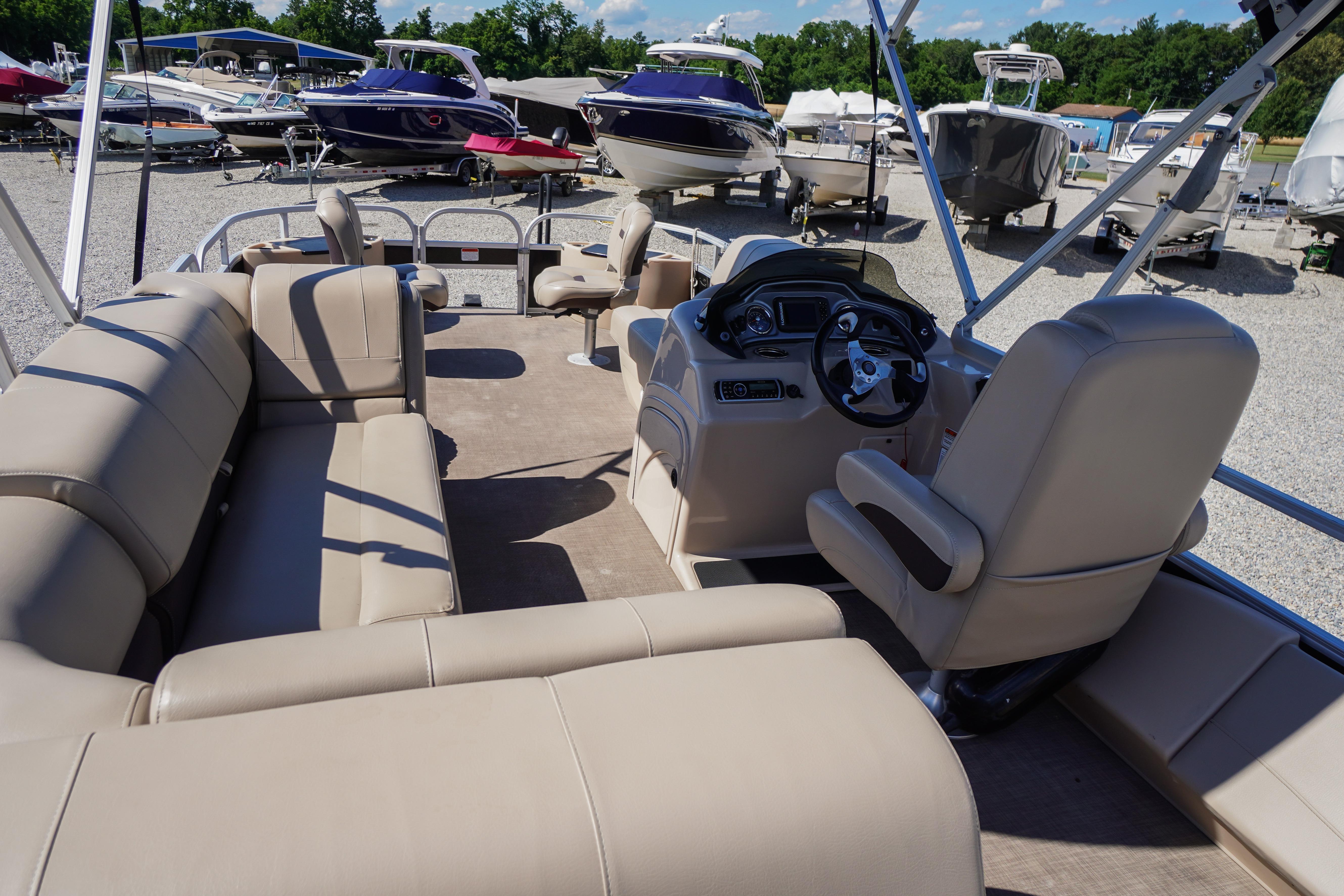 2019 SUNTRACKER Fishin' Barge 22 DLX interior with beige seating and steering console.