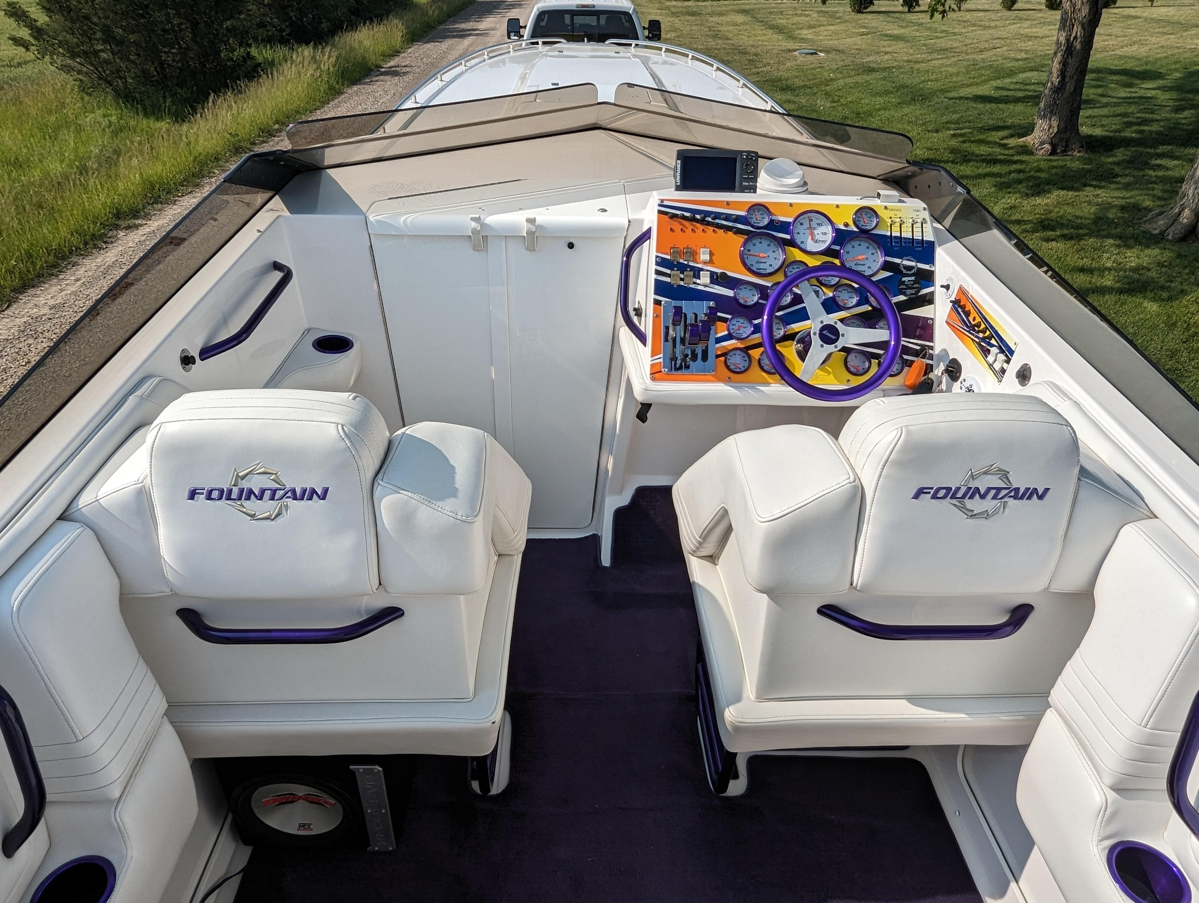 2006 Fountain 42 boat interior with white seats, vibrant dashboard, and steering wheel.
