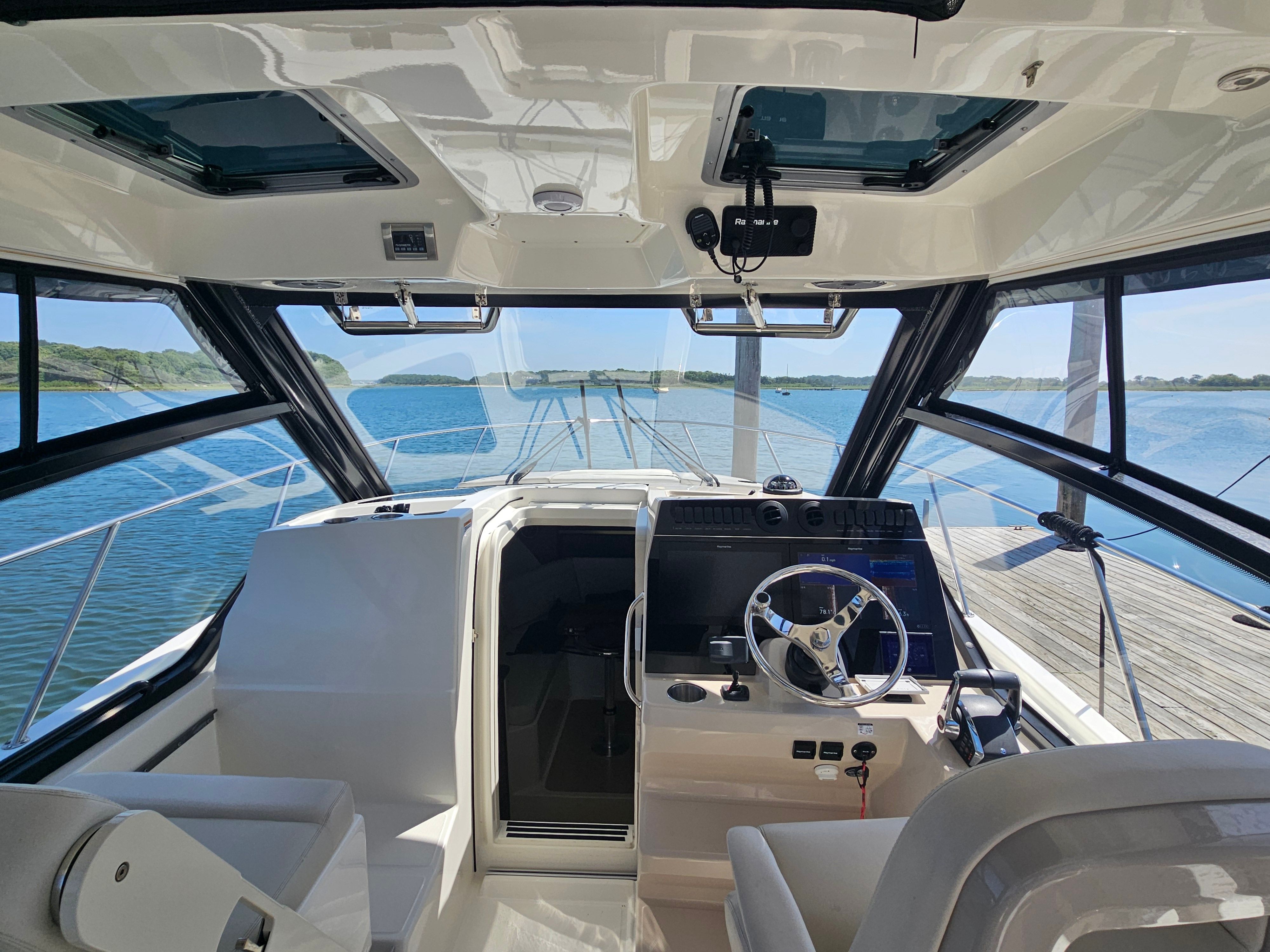 The cockpit of a 2023 Boston Whaler 325 Conquest overlooking the water.