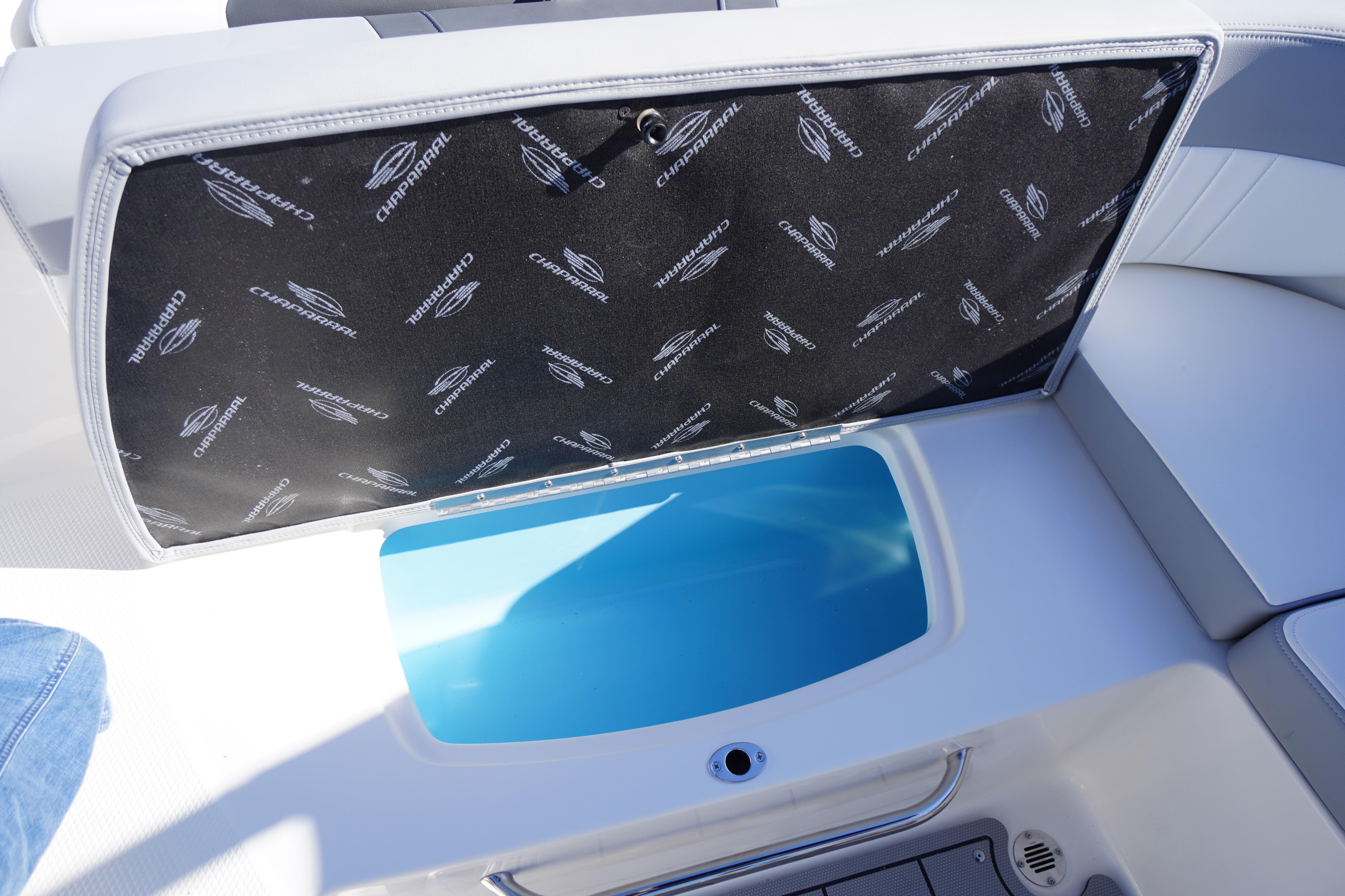 2026 Chaparral 23 SSi OB boat storage compartment with branded cover and blue interior.