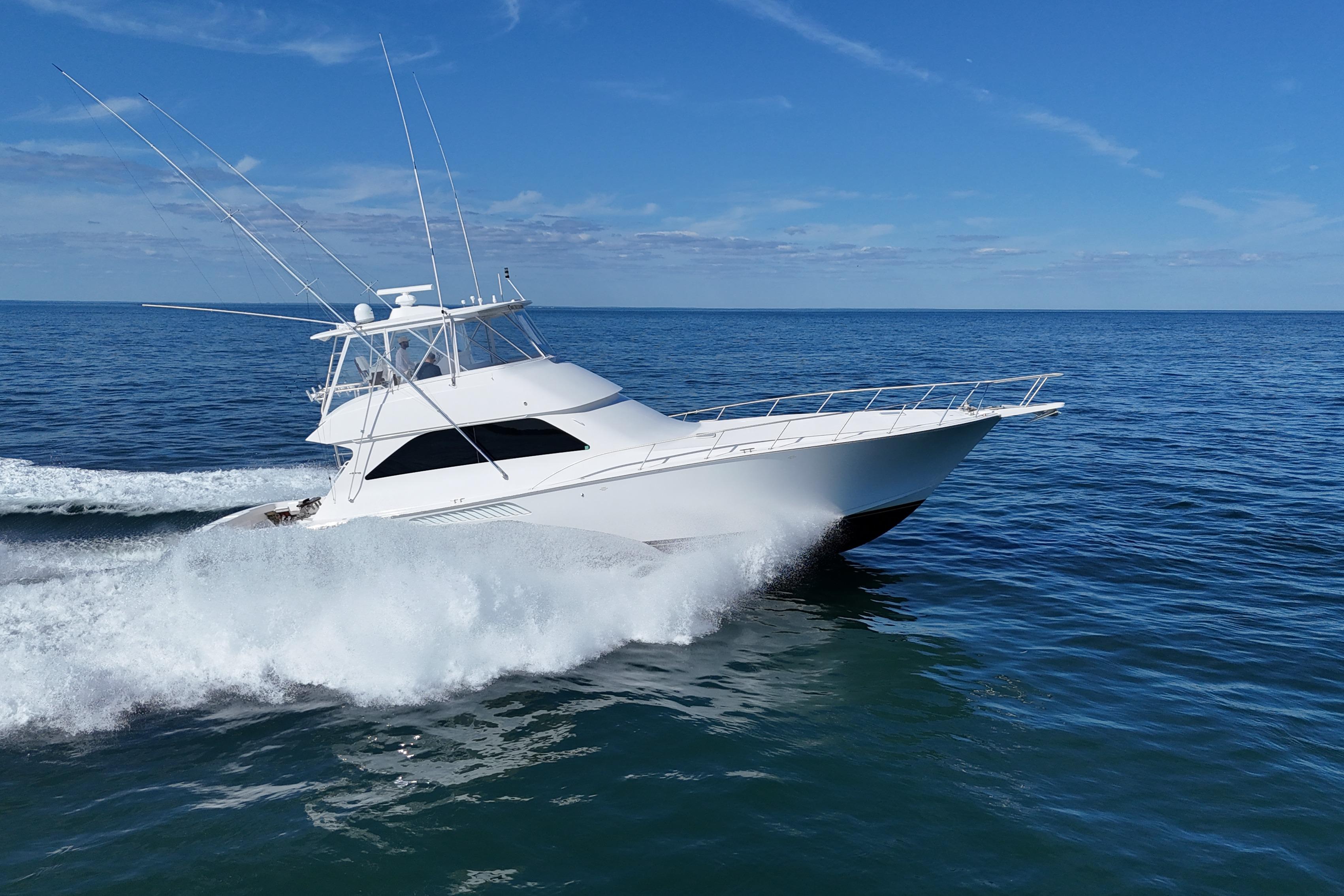 2006 Viking 56 Convertible yacht cruising on open sea under clear blue sky.