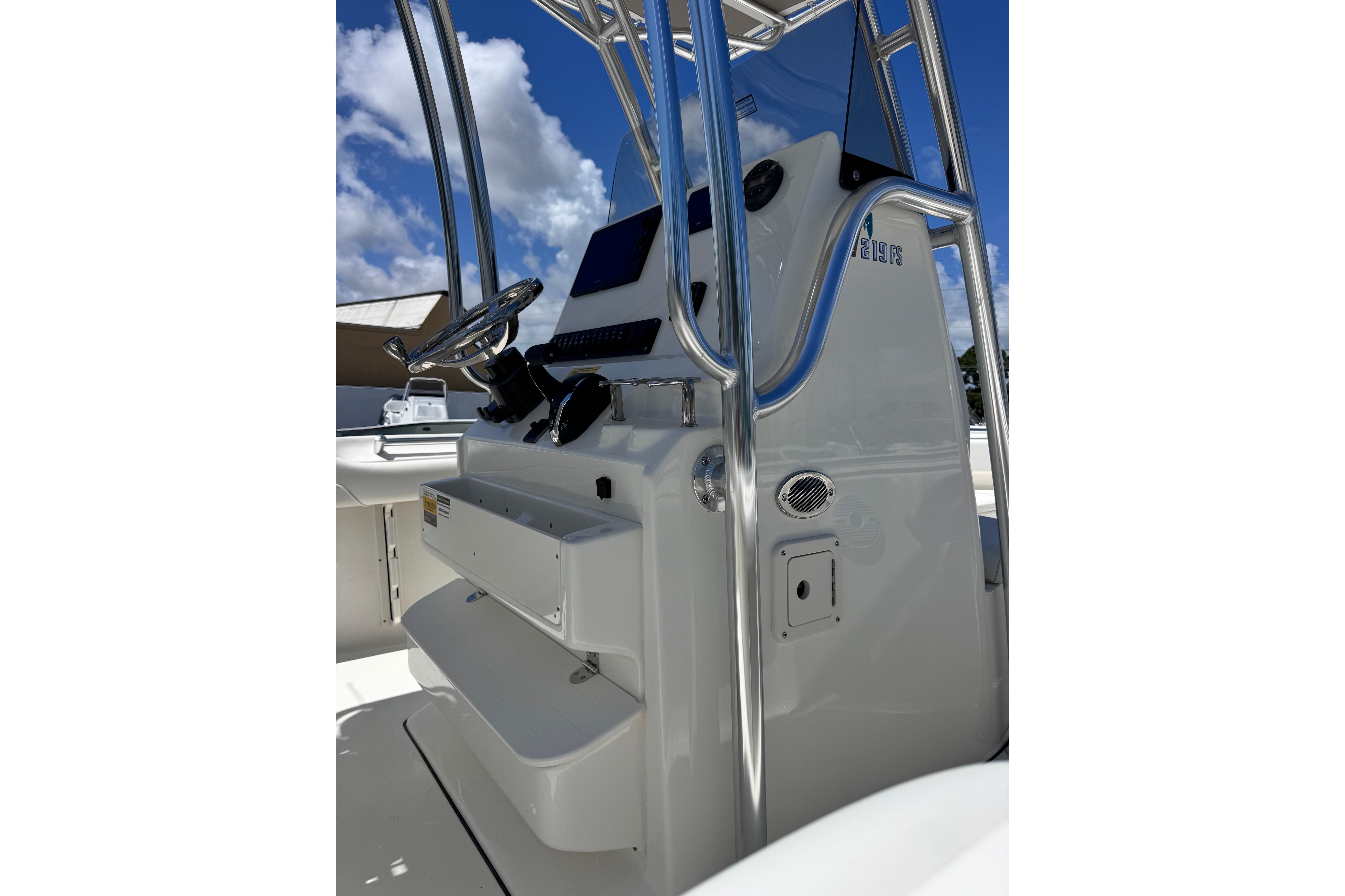 2026 Key West 219 FS boat console with steering wheel and controls under blue sky.