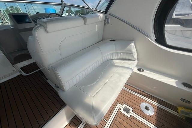 2004 Cruisers Yachts 3372 Express interior with white seating and wooden flooring.