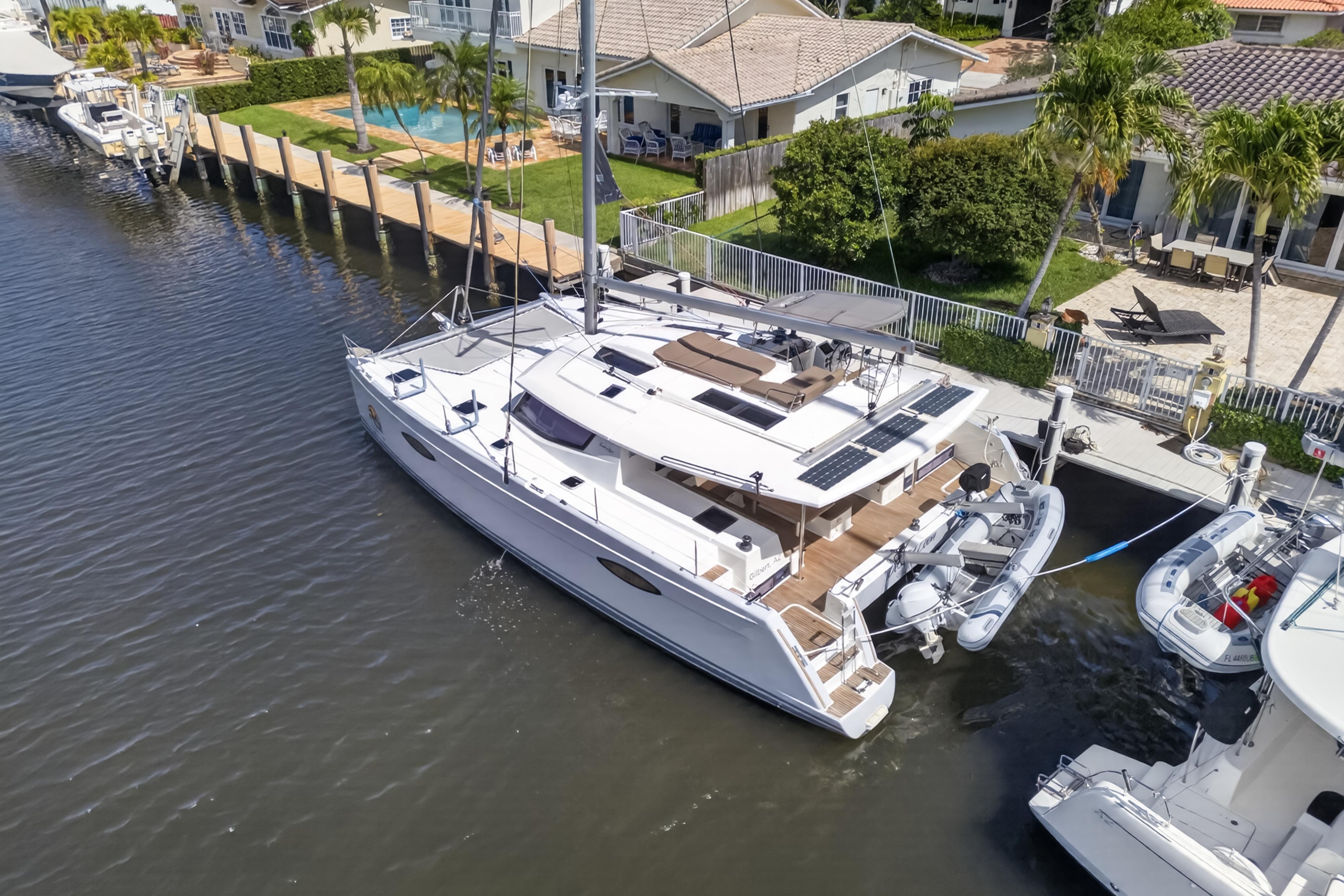 Aerial view of 2015 Fountaine Pajot Helia 44 catamaran docked by waterfront homes.