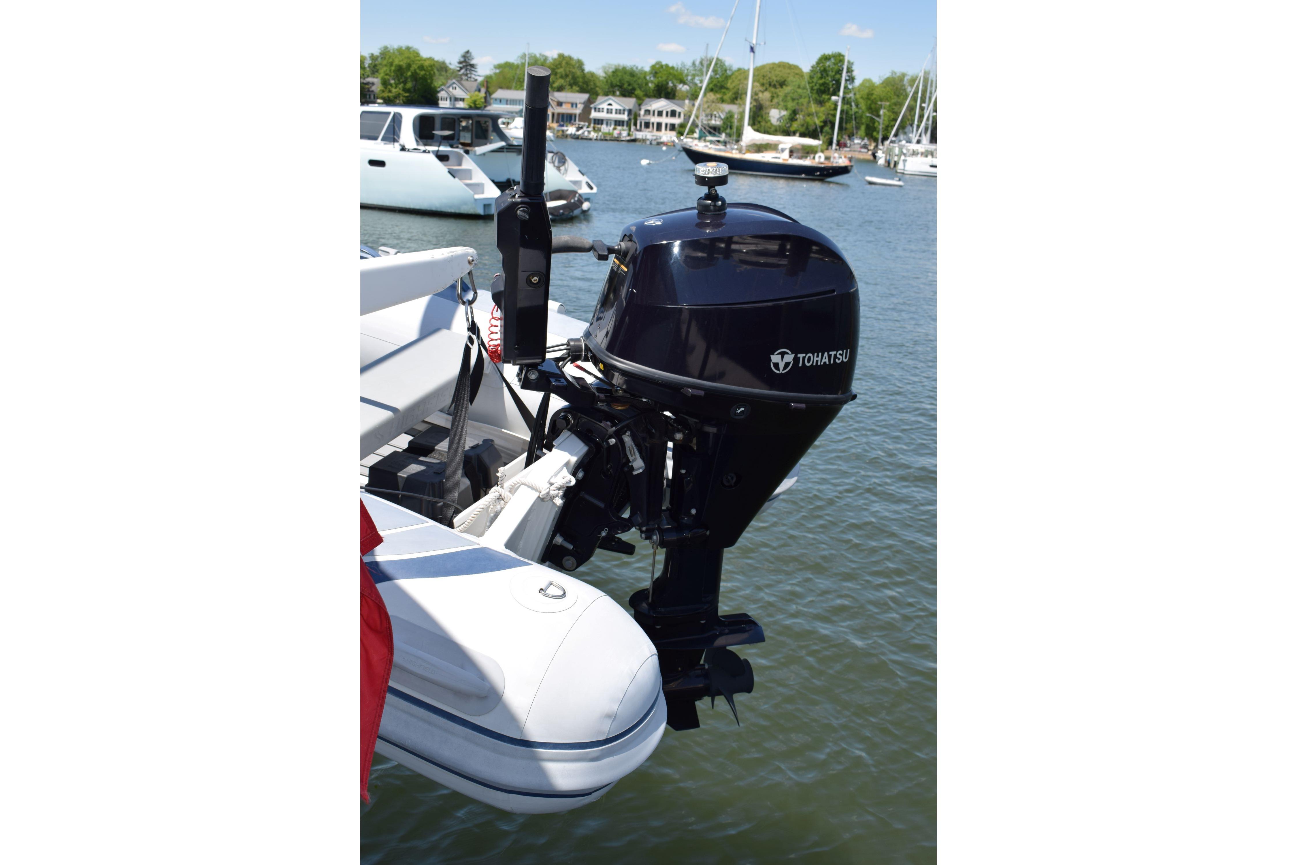 Tohatsu outboard motor on a Cheoy Lee 52 Motorsailer, 1980, docked in a marina.