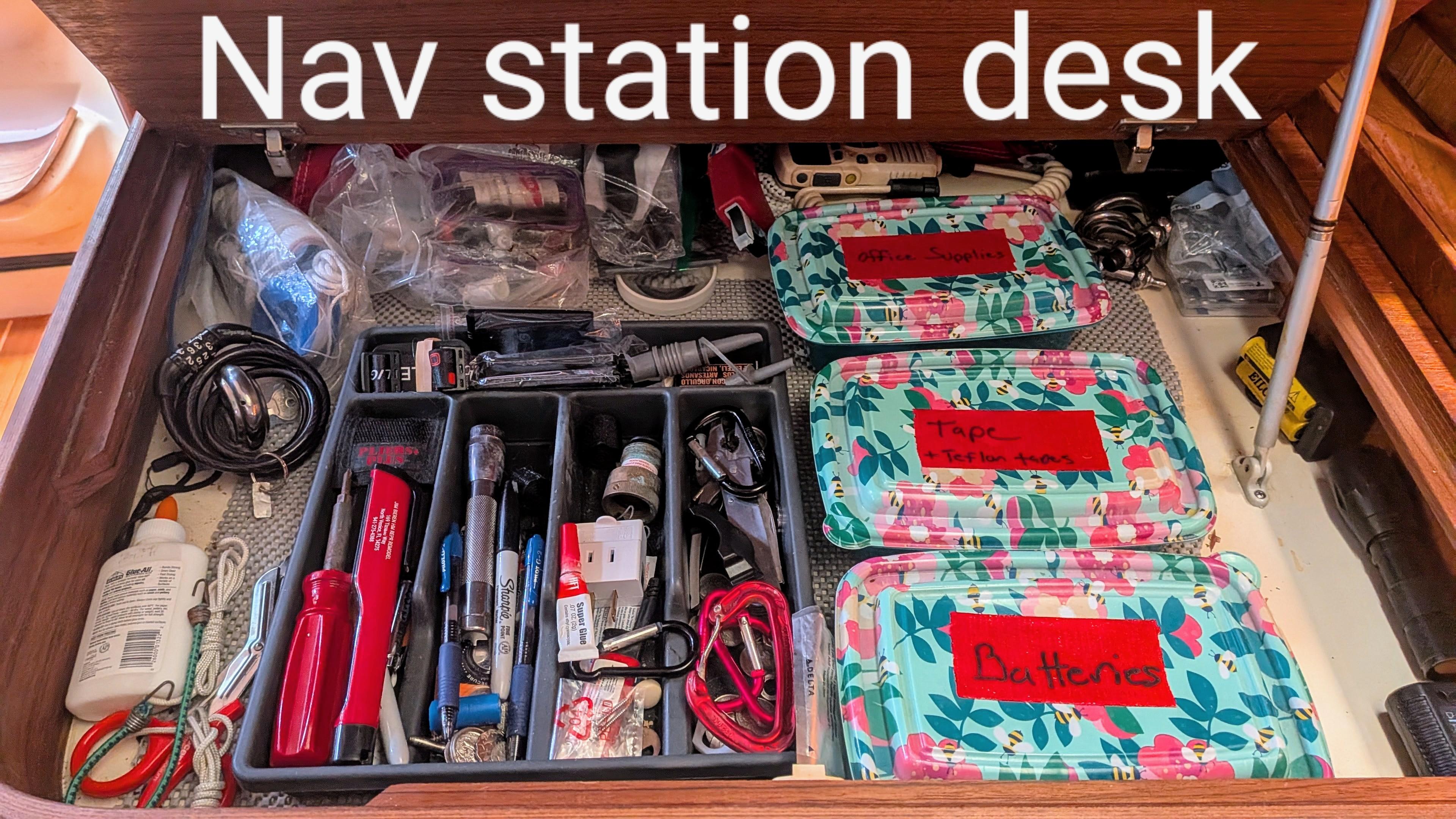 Nav station desk with organized tools and supplies on a 2001 Hunter 380 sailboat.