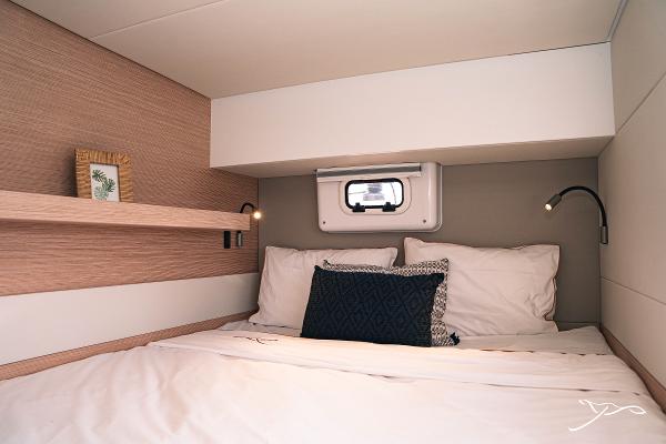 Cozy cabin interior of 2025 Nautitech 40 Open catamaran with modern bedding and reading lights.