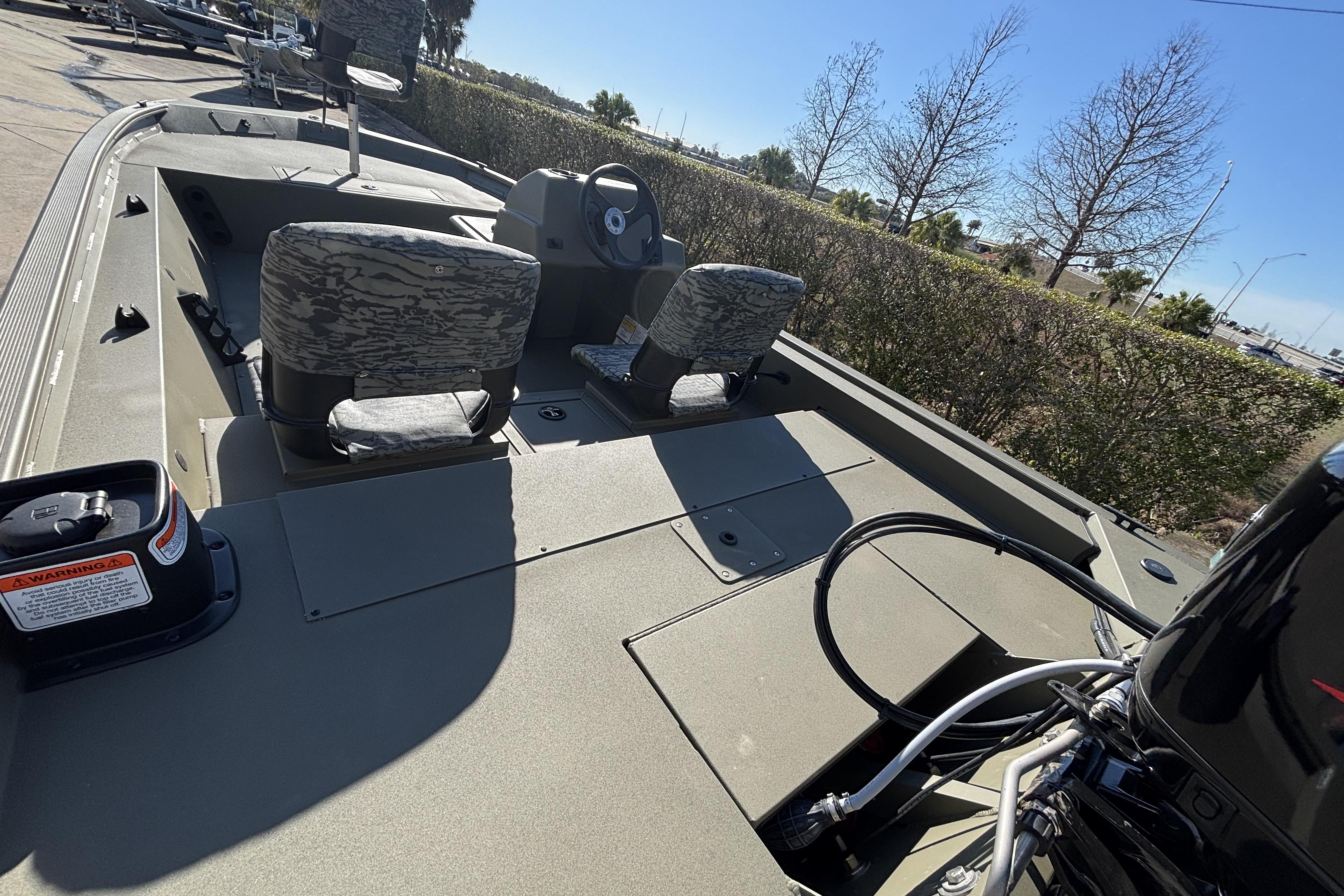 2026 Tracker Grizzly 1754 SC boat interior with camo seats and steering console.