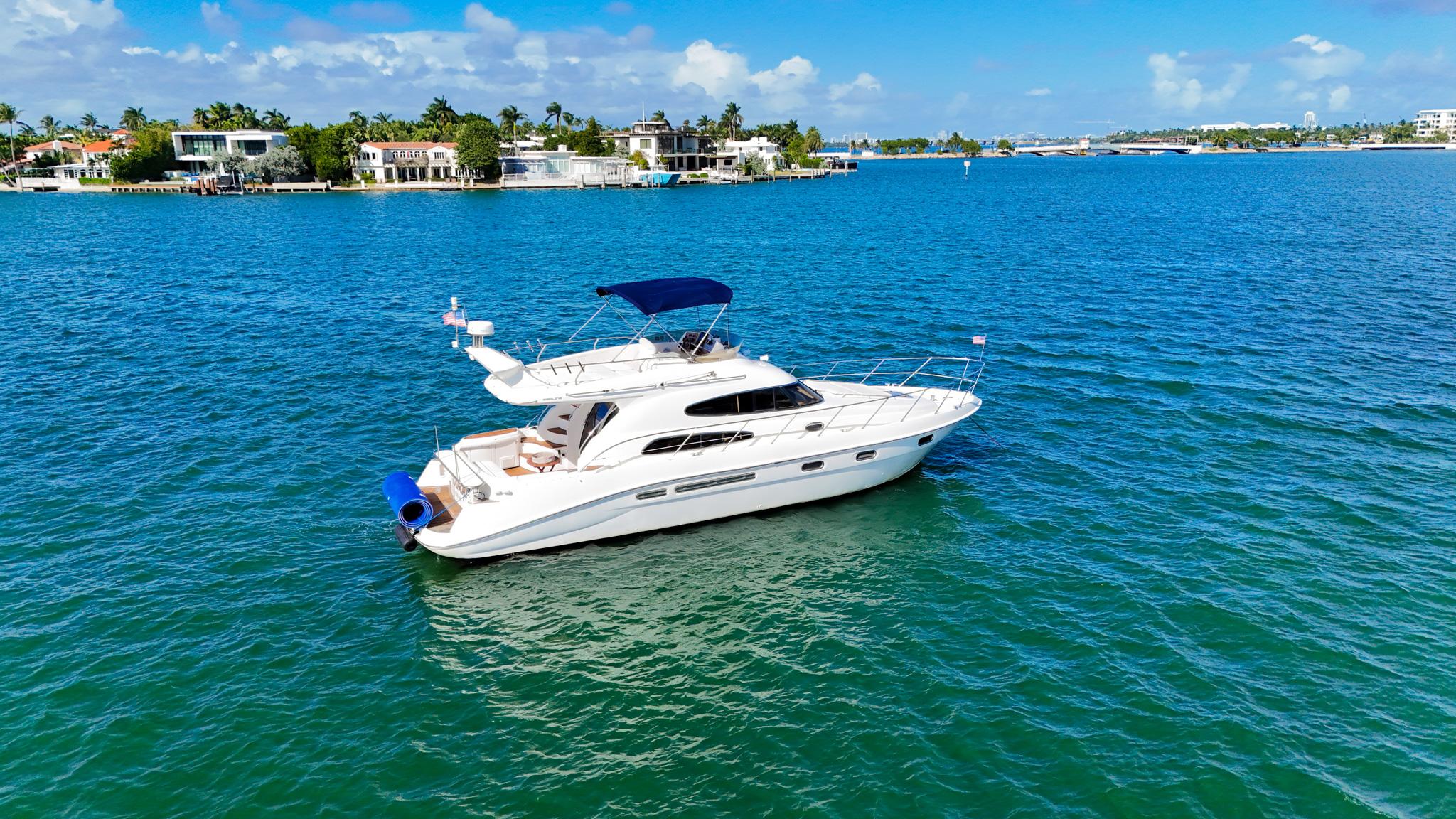 2004 Sealine 47 yacht cruising on clear blue waters under a sunny sky.