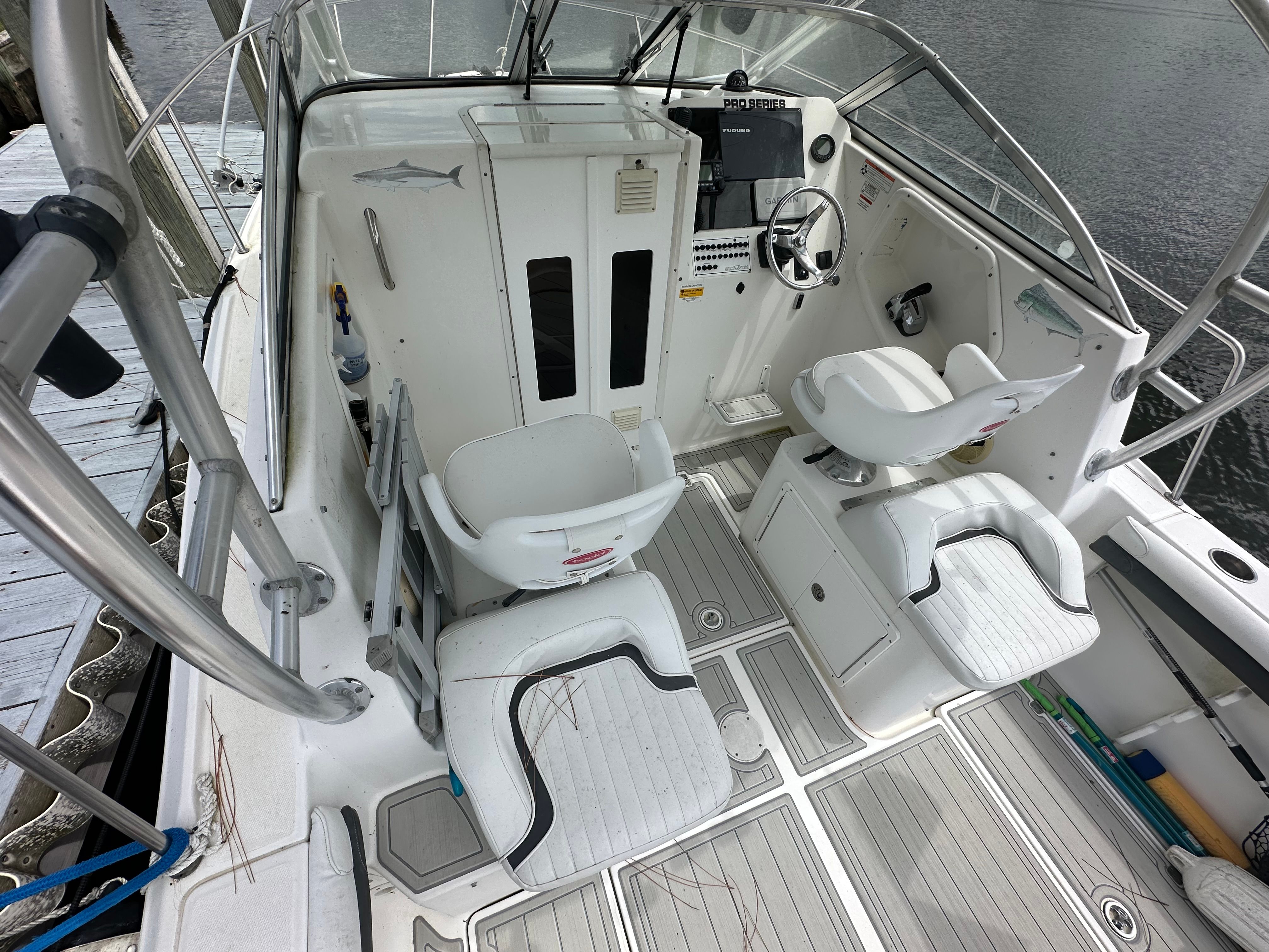 The image shows the cockpit of a 2009 Sea Fox 256WA boat with two white seats.