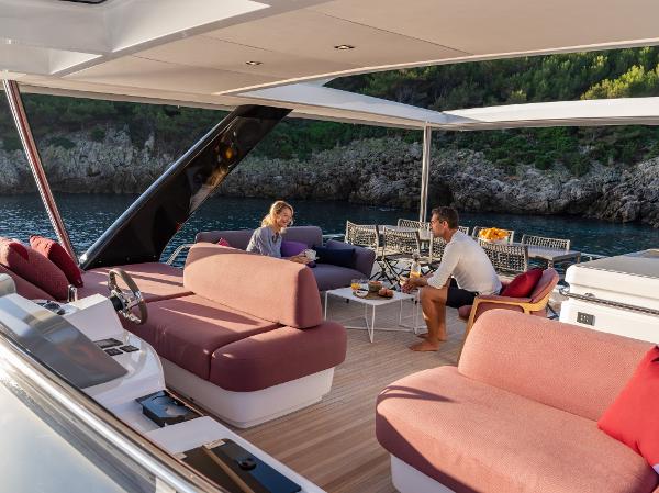 Luxurious Lagoon SIXTY 7 yacht interior, 2025 model, with people enjoying a scenic ocean view.