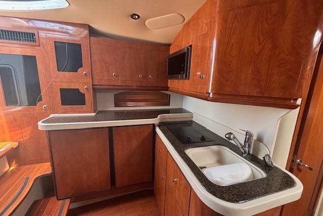 2005 Four Winns 378 Vista yacht interior with wooden cabinetry and modern kitchen amenities.