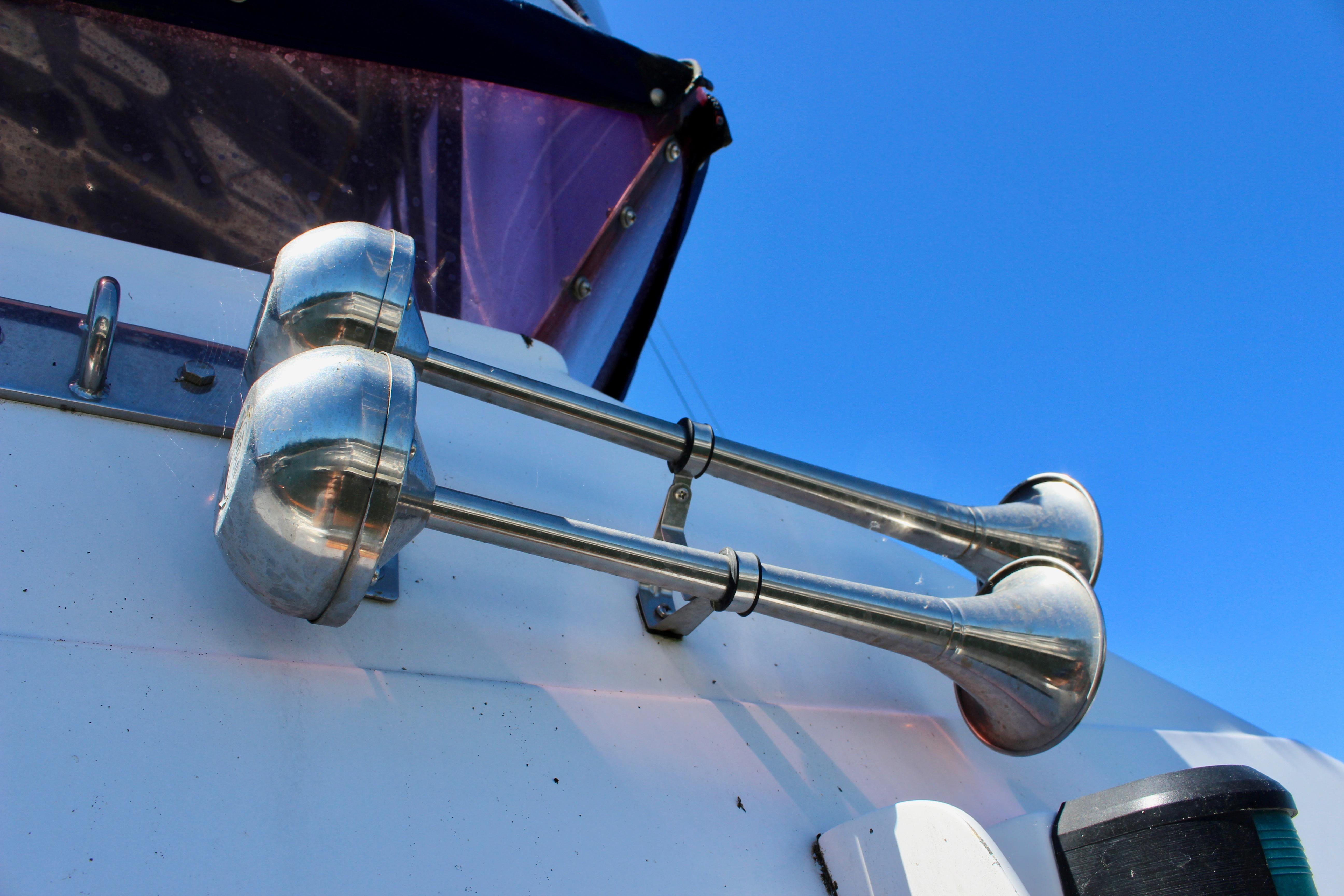 Chrome boat horns on a 1986 Kha Shing Spindrift 46 against a clear blue sky.
