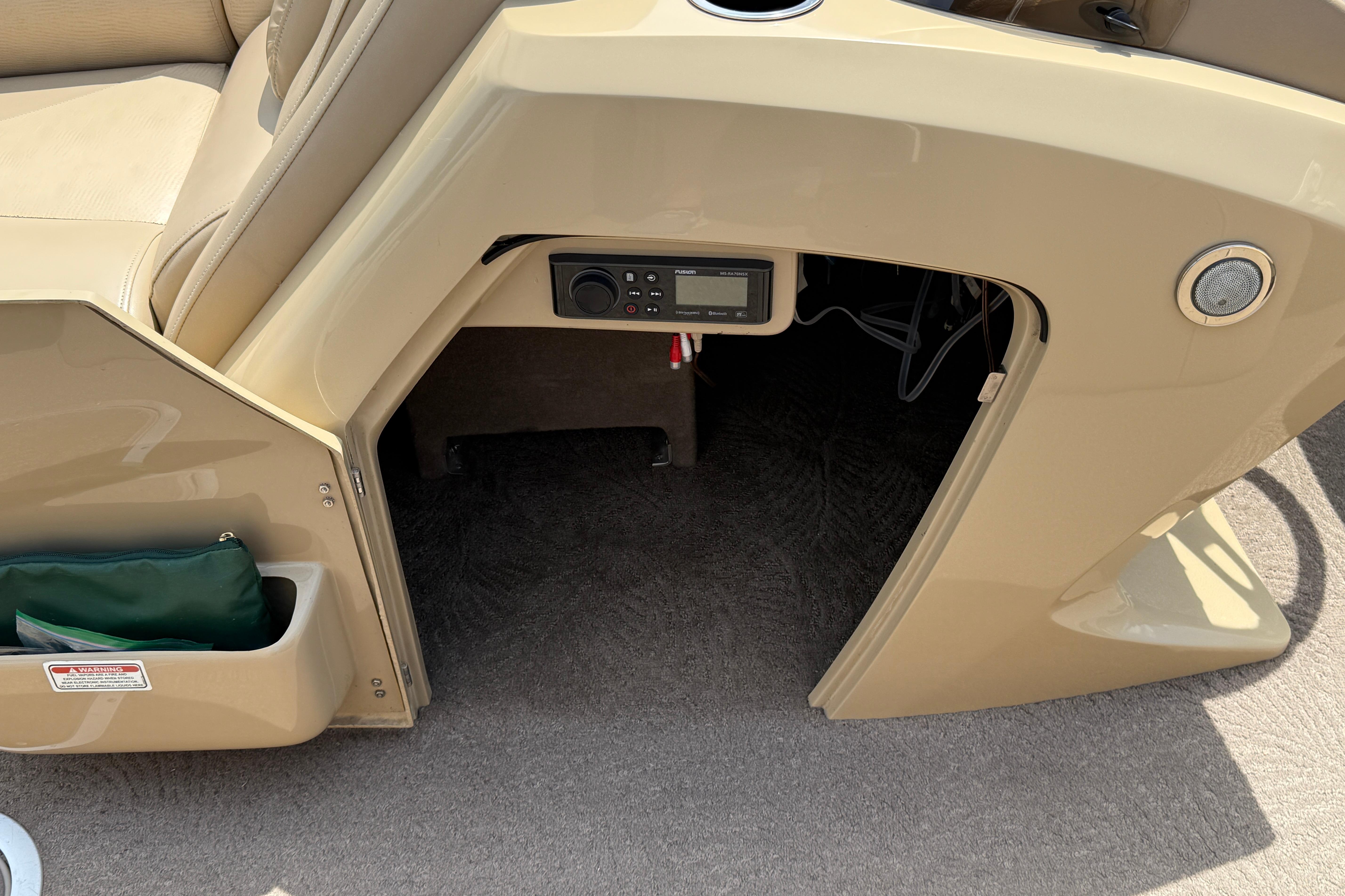 Interior view of a 2011 Bennington 2575QCW I/O boat, featuring a control panel and storage compartment.
