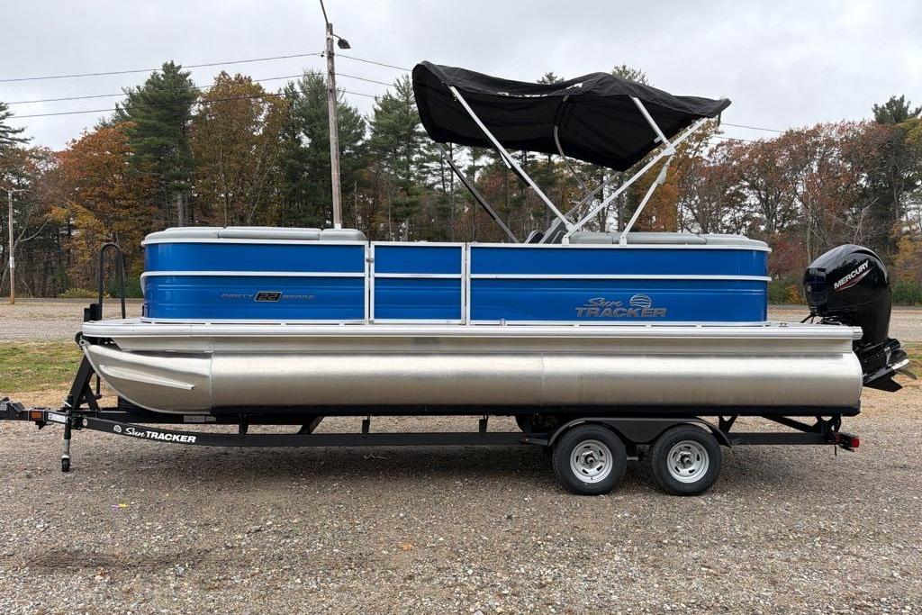 2026 Sun Tracker Party Barge 22 DLX pontoon boat on trailer, parked outdoors.