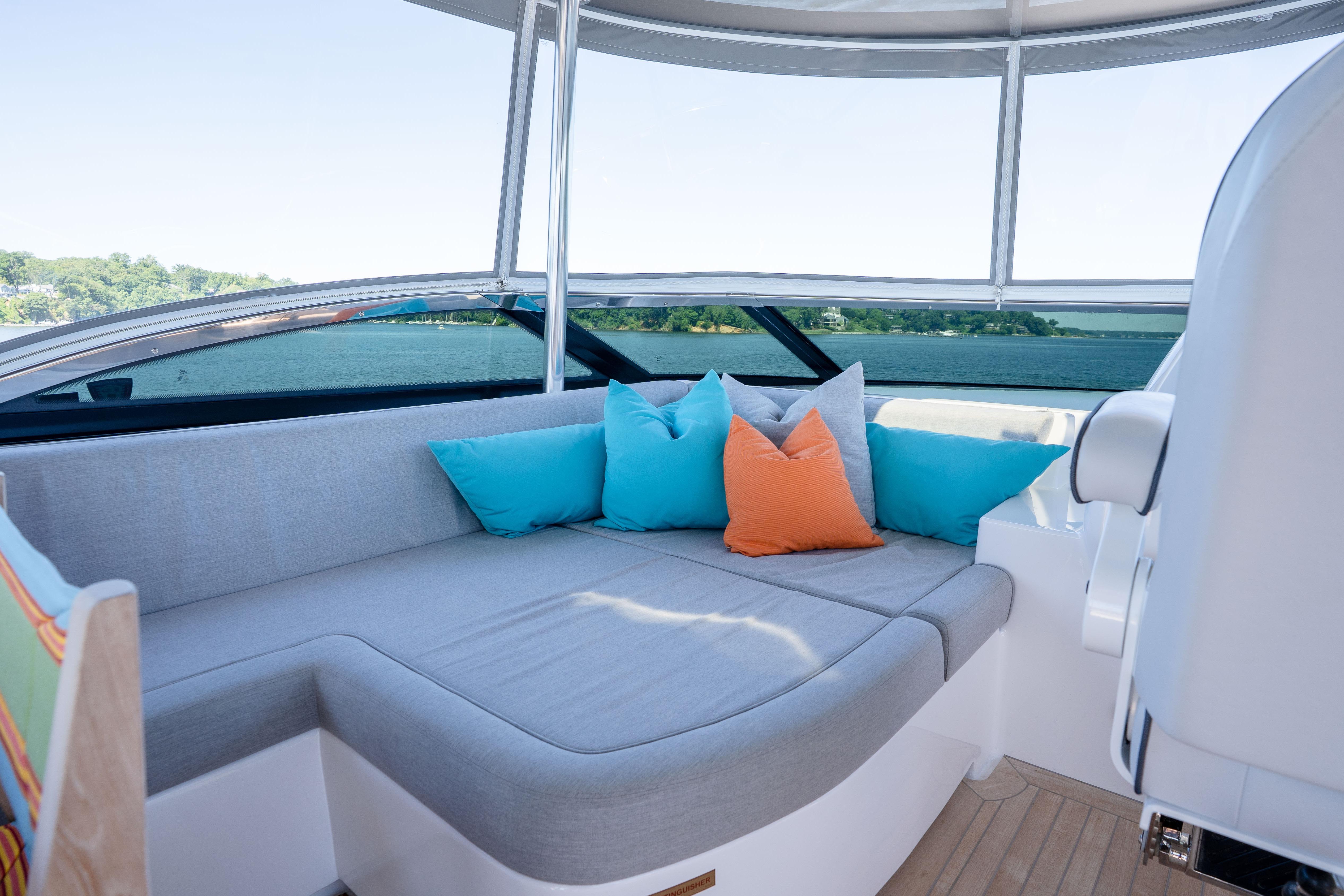 Luxurious seating area on 2021 Hatteras M75 Panacera yacht with colorful cushions.