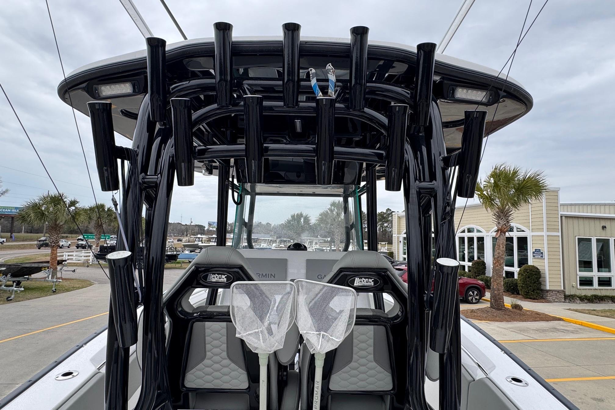 2024 Cape Horn 32 XS boat with rod holders and seating, docked near a building.