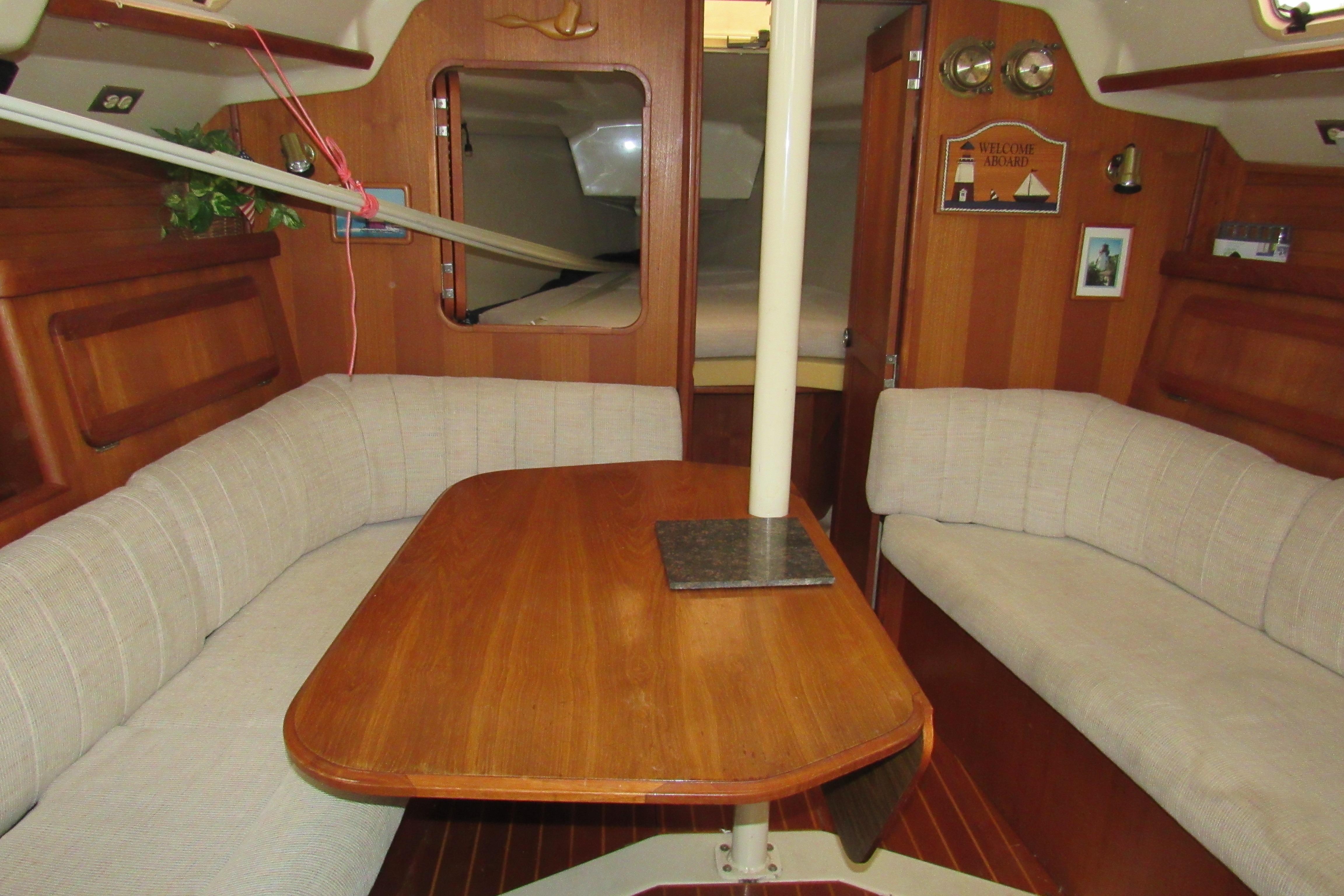 Interior of 1991 Marlow-Hunter 37.5 sailboat with wooden table and cushioned seating.