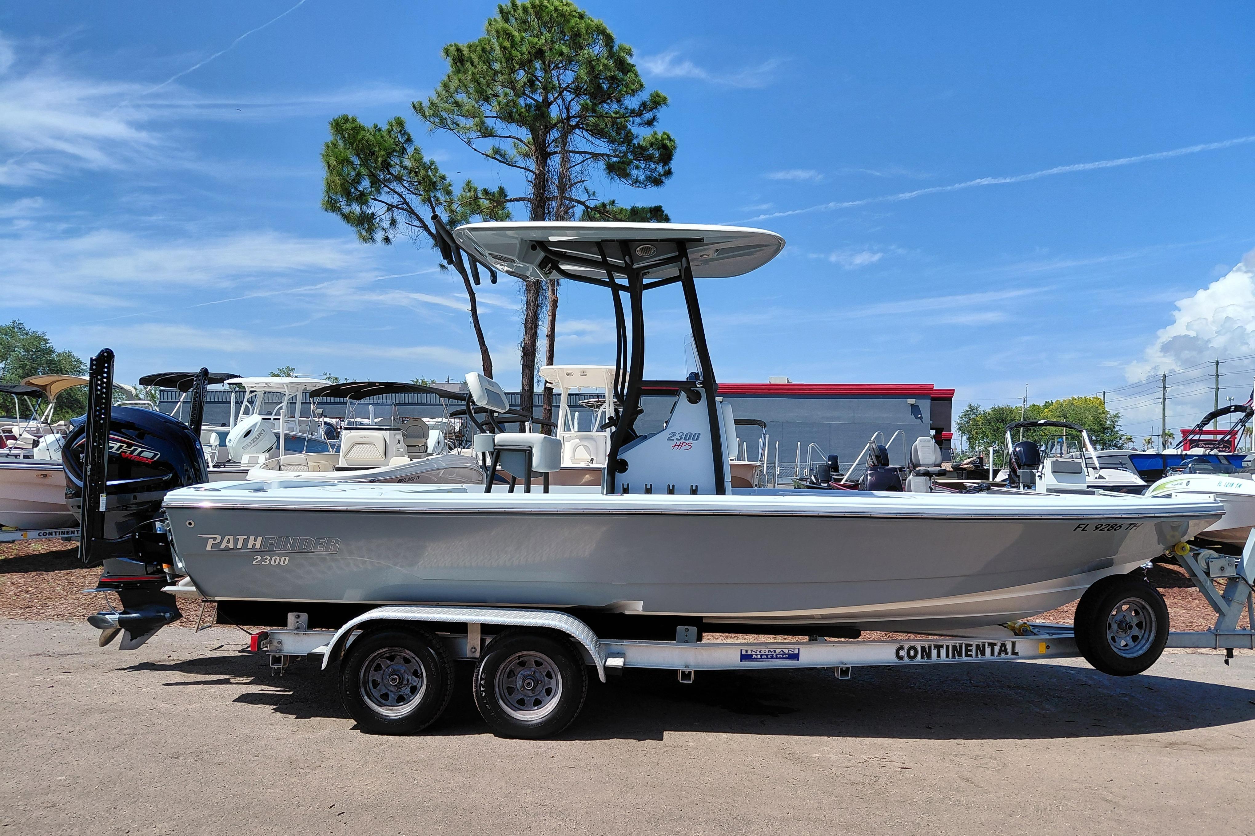 2022 Pathfinder 2300 HPS boat on trailer, parked outdoors under clear blue sky.