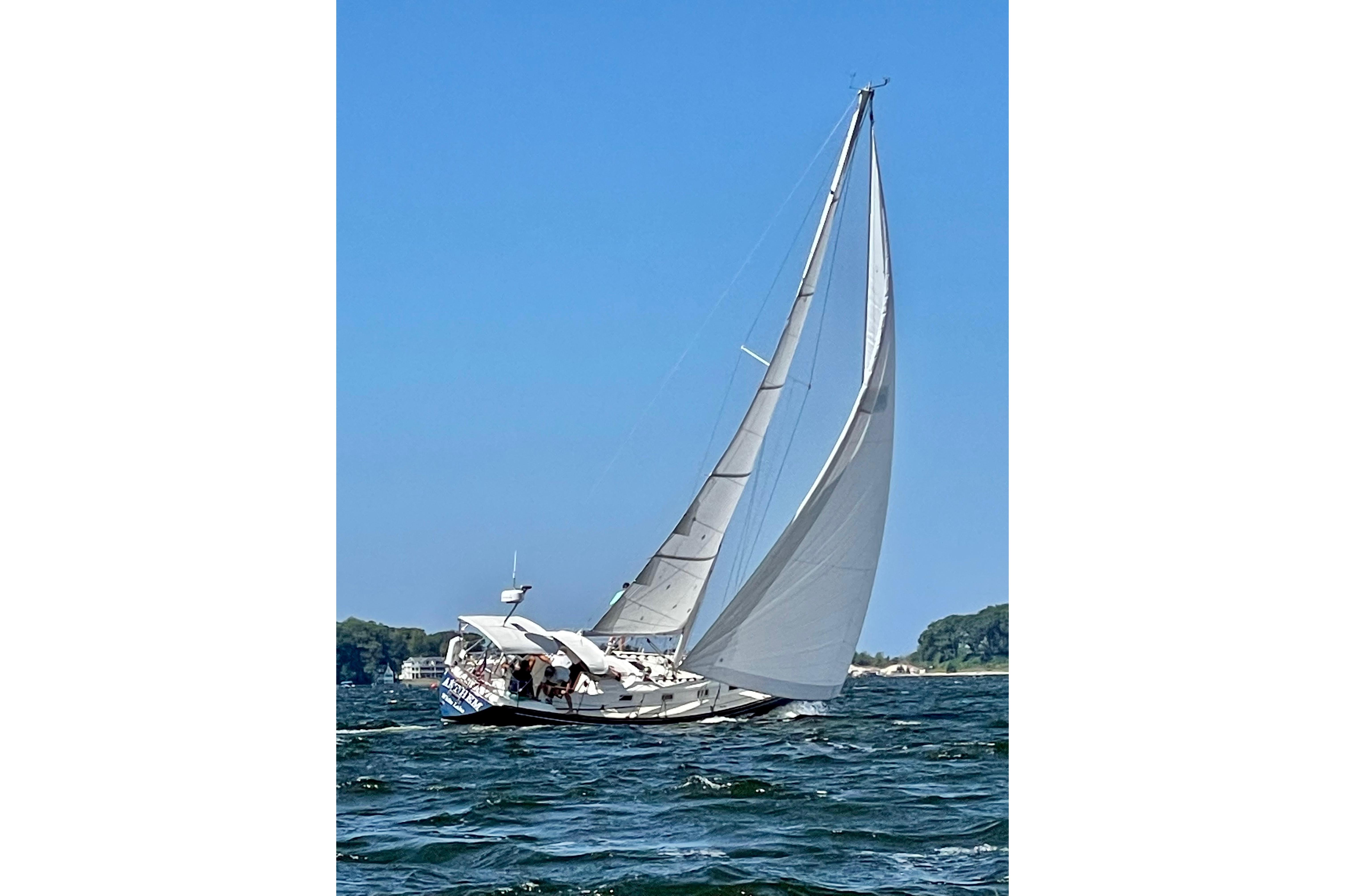 1986 Tartan 37' sailboat navigating on open water under clear blue skies.