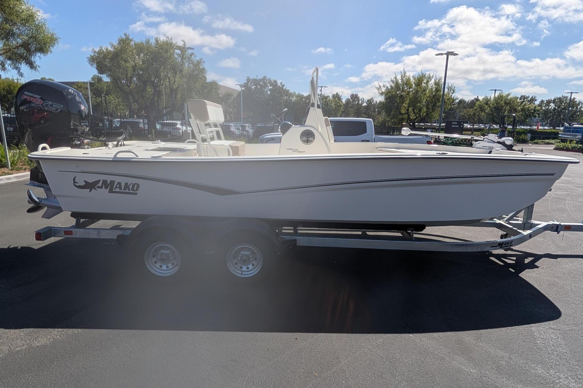 2026 Mako Pro Skiff 19 CC boat on trailer, parked outdoors under a sunny sky.