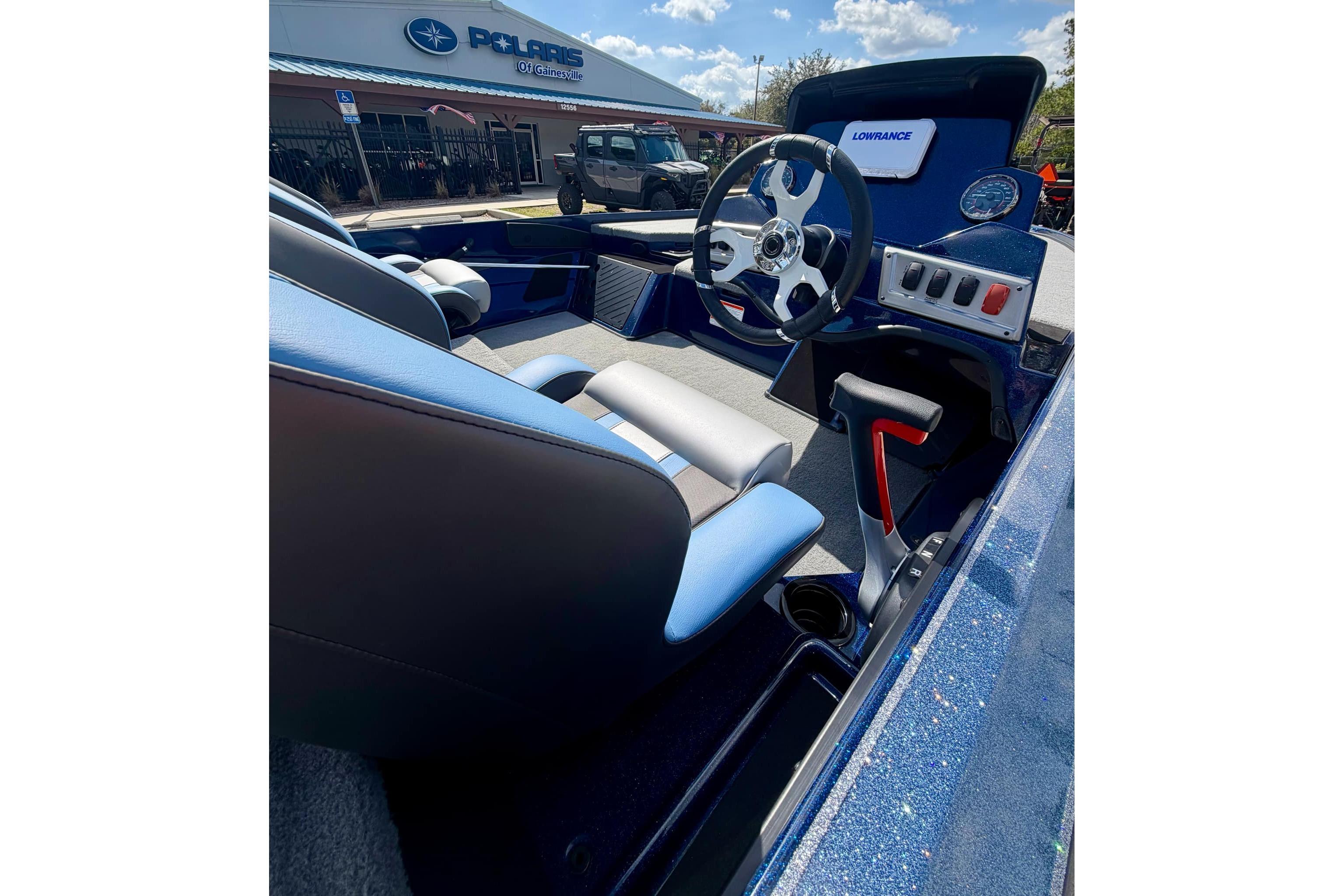 2026 Nitro Z18 boat interior with steering wheel and controls, parked outside dealership.