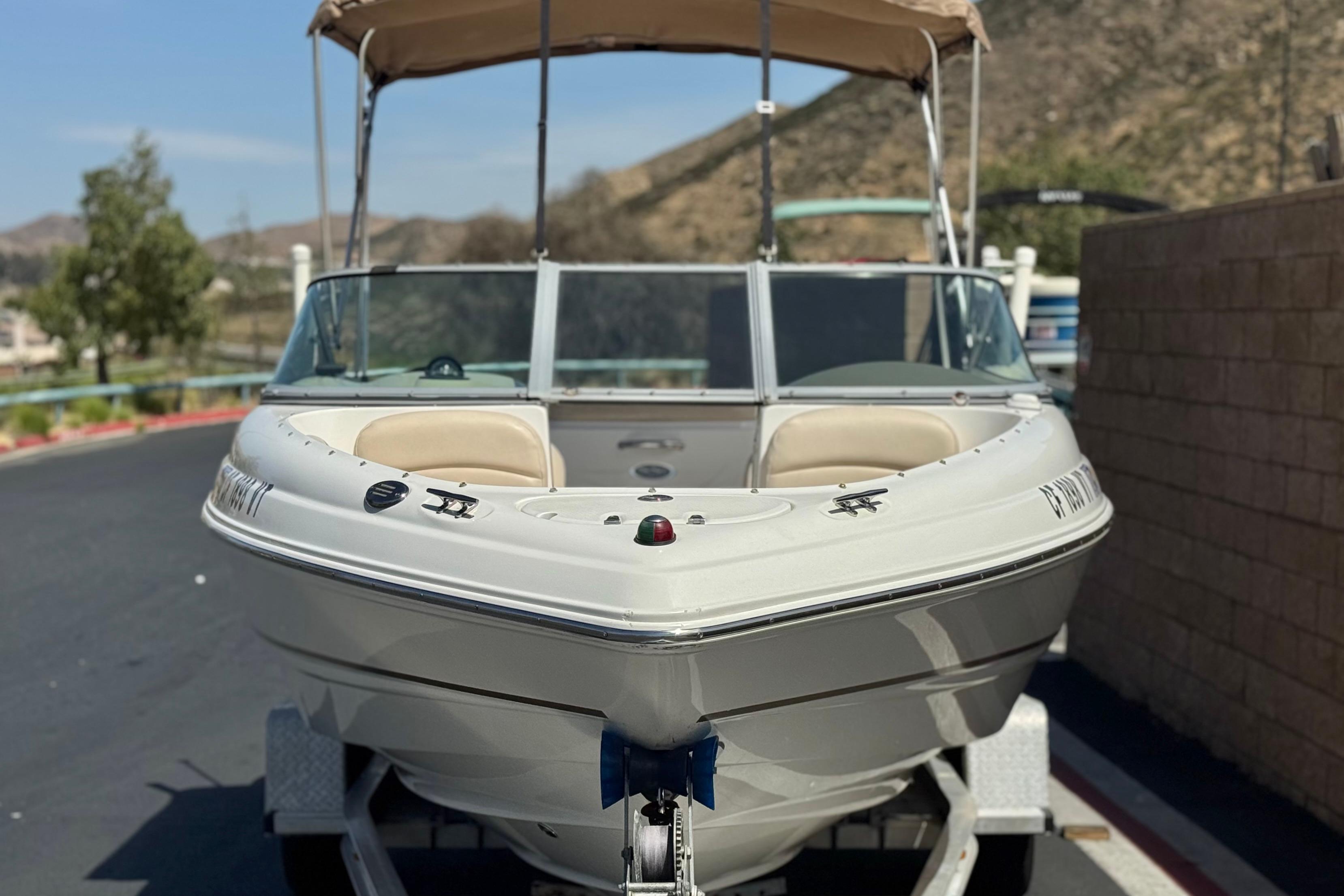 2006 Chaparral 190 SSi boat on trailer, parked outdoors with scenic background.