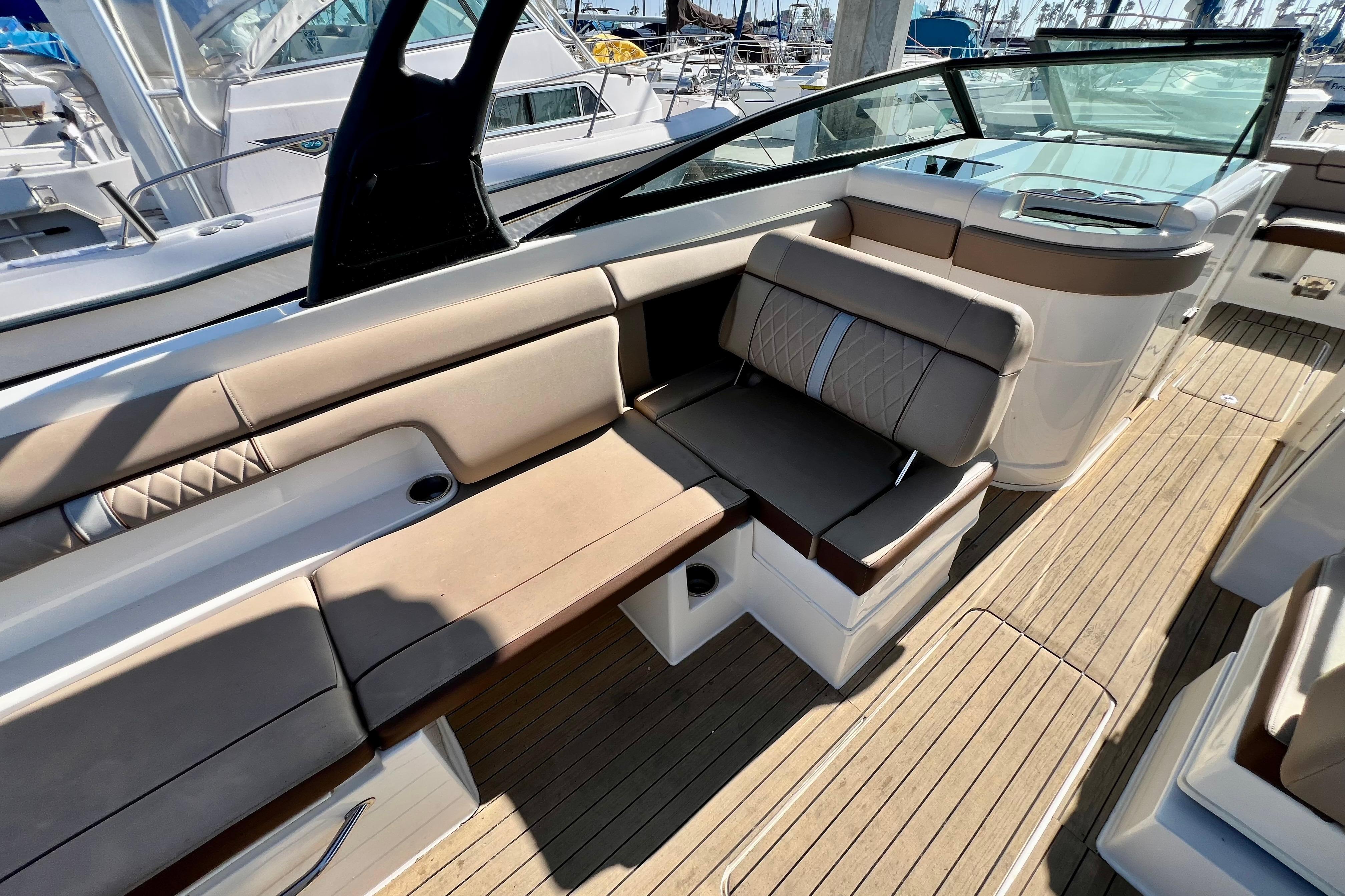 2016 Sea Ray 290 Sundeck Outboard interior with beige seating and wooden deck.