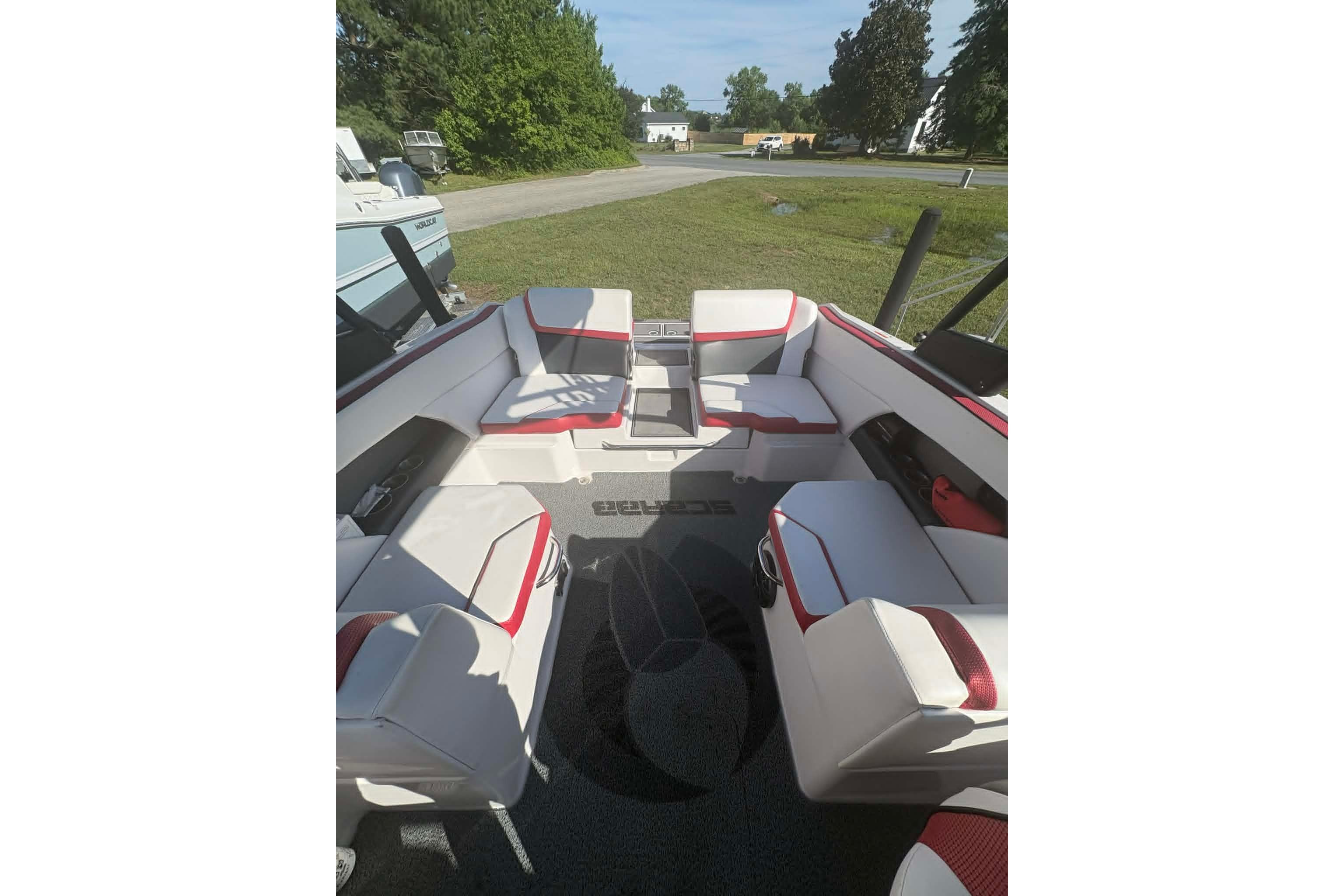 2016 Scarab 255 H.O. Impulse boat interior with white and red seating, outdoor setting.