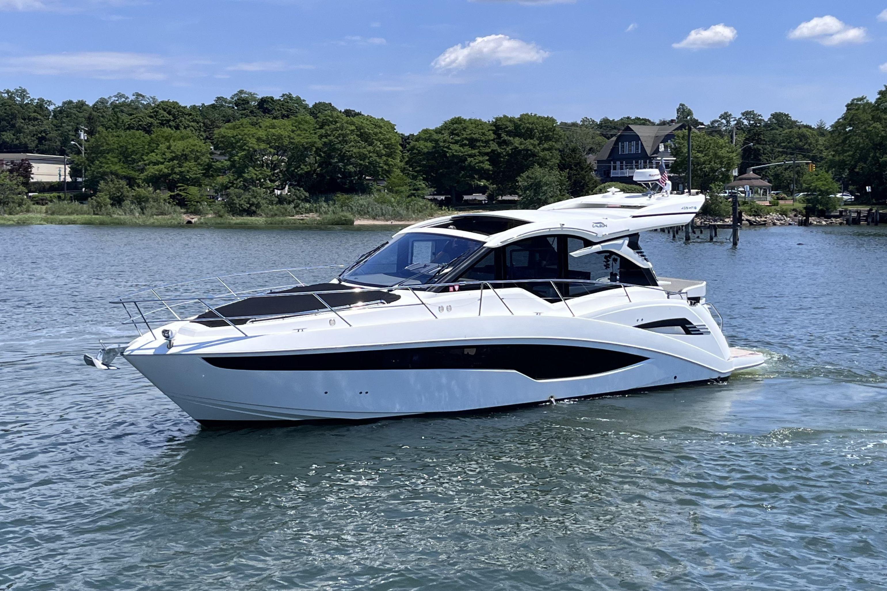 2024 Galeon 425 HTS yacht cruising on a serene lake under a clear blue sky.