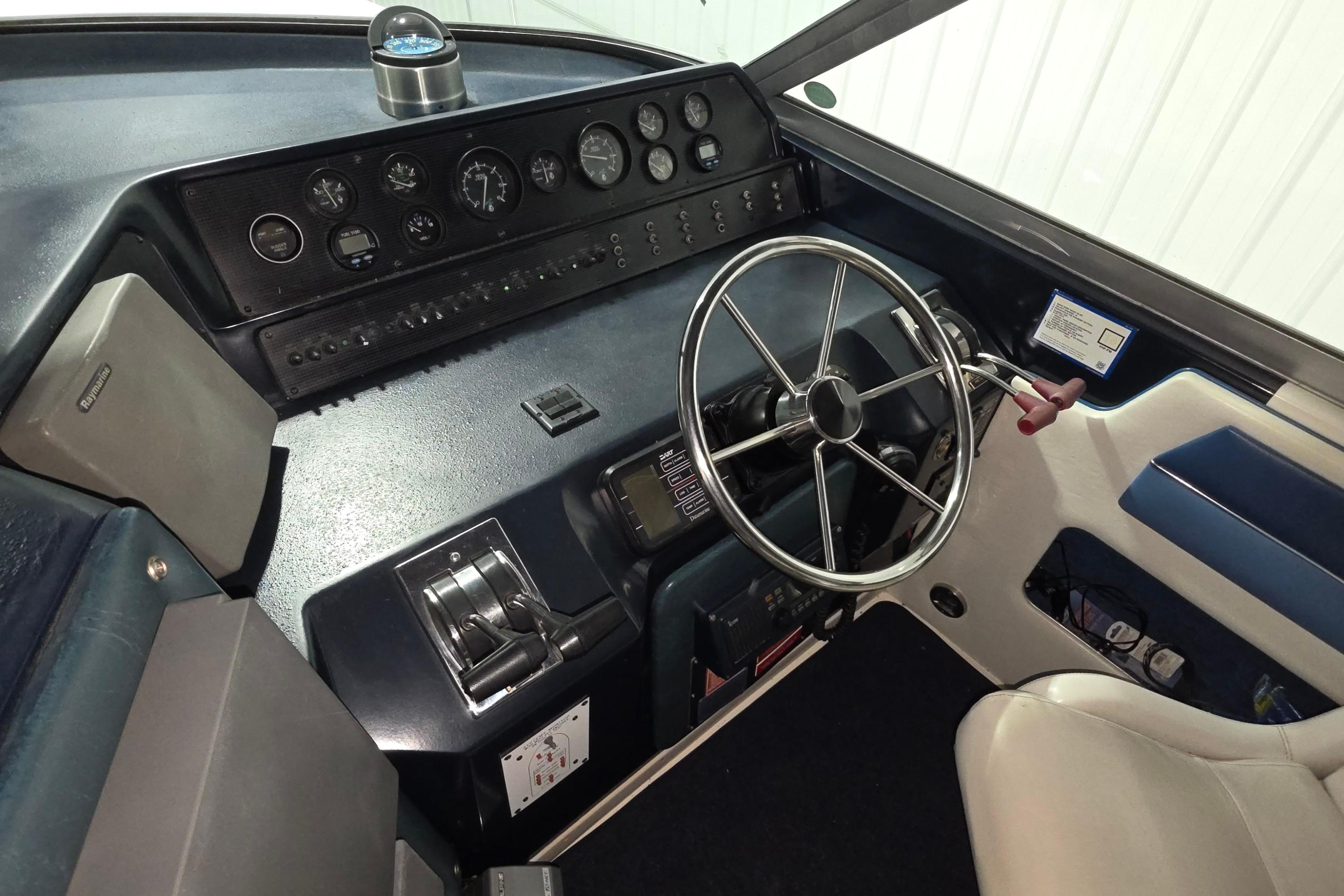 1989 Sea Ray 420 Sundancer helm with steering wheel and control panel.