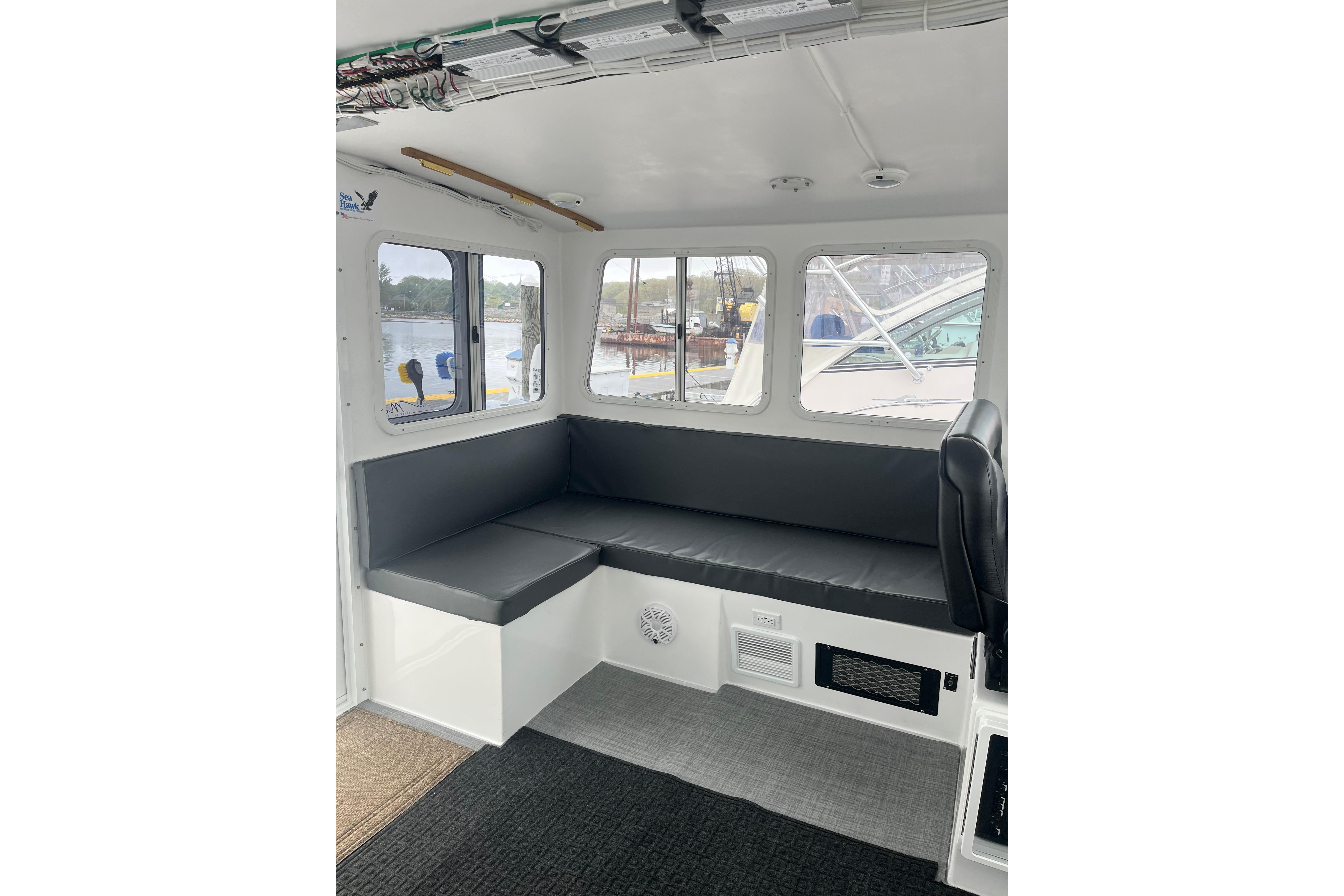 Interior of 2018 H&H Marine Osmond Beal boat with seating and windows.