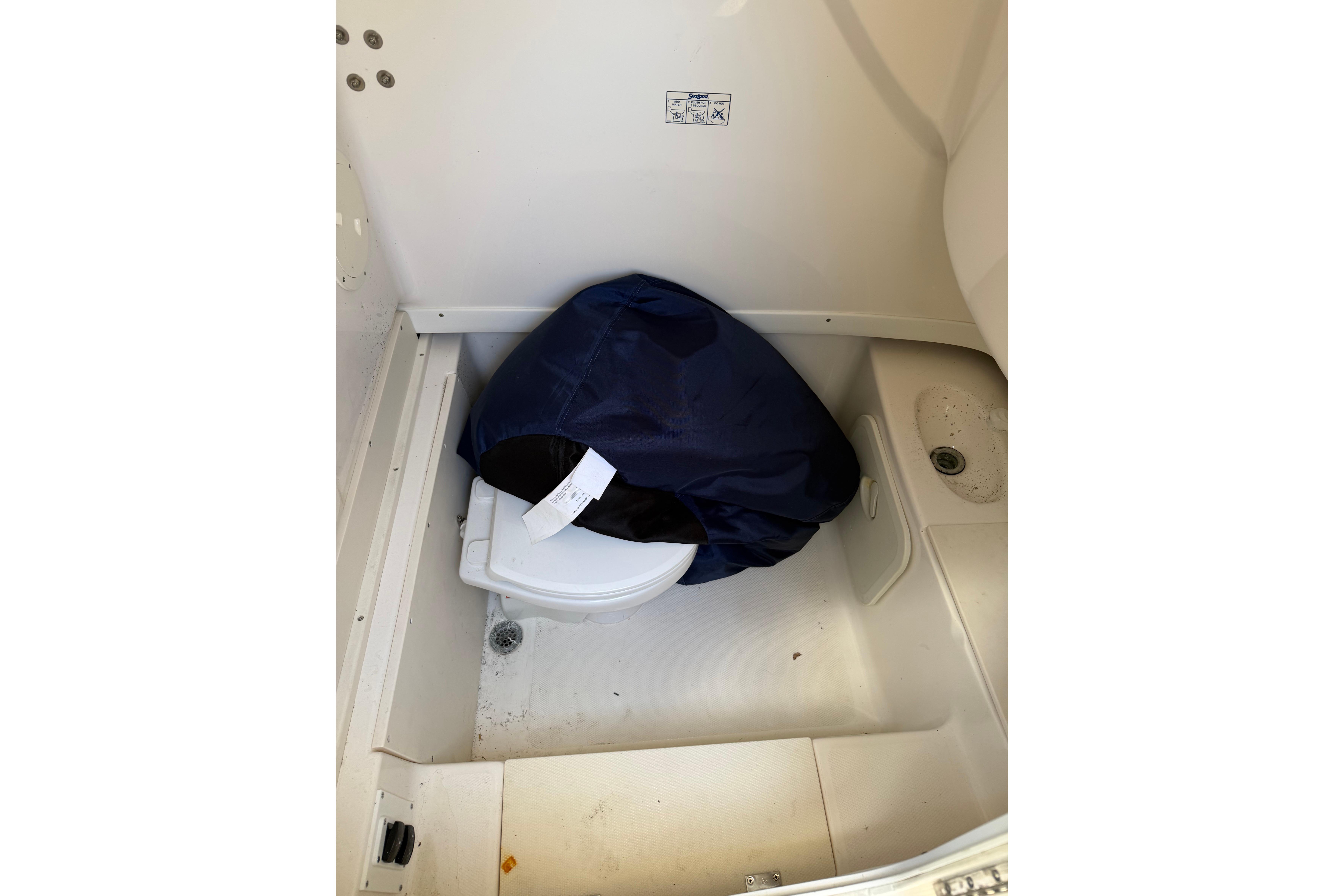 2007 Robalo R260 Center Console boat interior with covered toilet and drain.