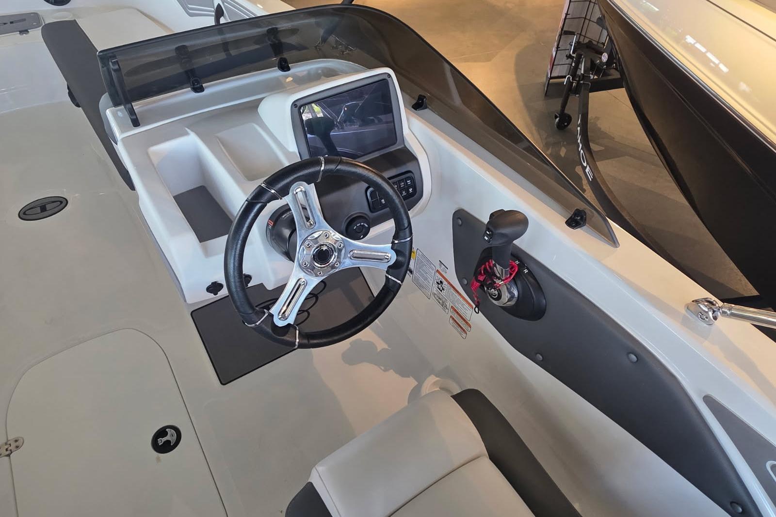 2026 Tahoe T21 boat cockpit with steering wheel, control panel, and seating.