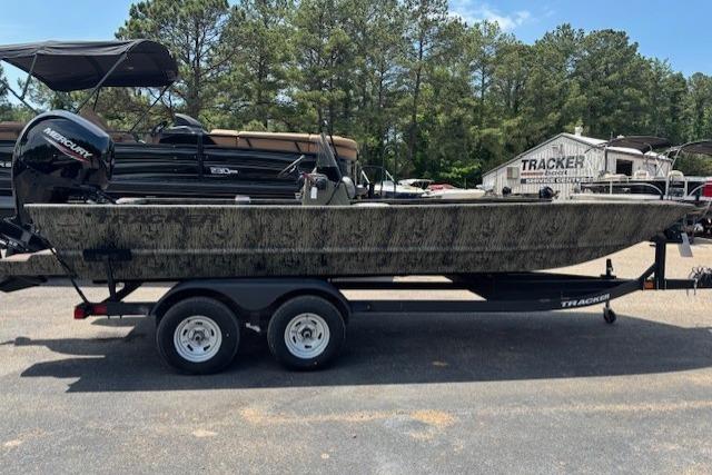 2026 Tracker Grizzly 2072 CC boat on trailer, parked outdoors with trees in background.