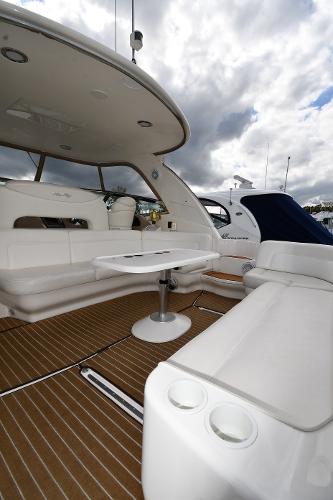 2003 Sea Ray 460 Sundancer yacht interior with seating and table under cloudy sky.