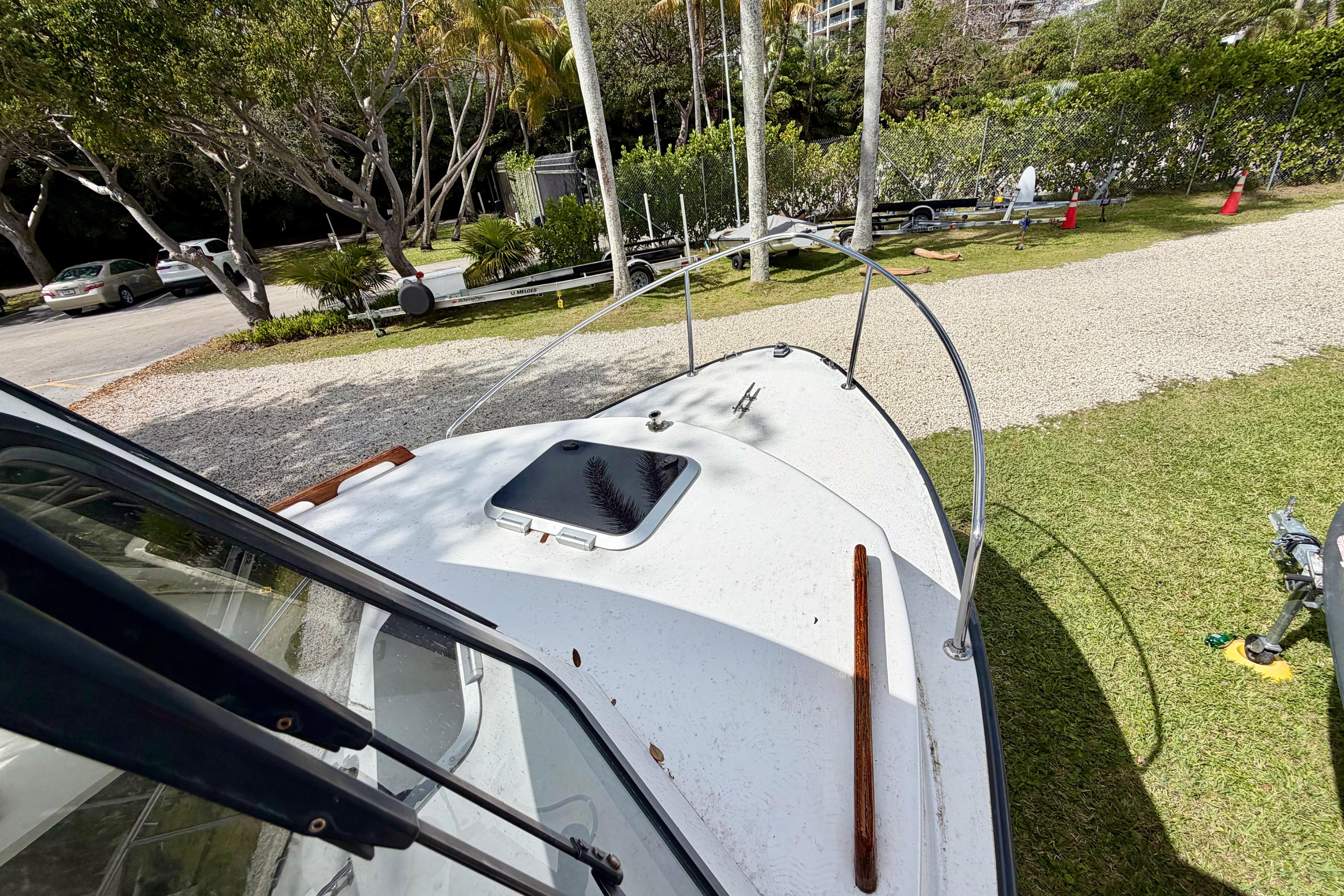 2000 Eastern 22 Lobster Fisherman boat on grassy area, surrounded by trees and parked cars.