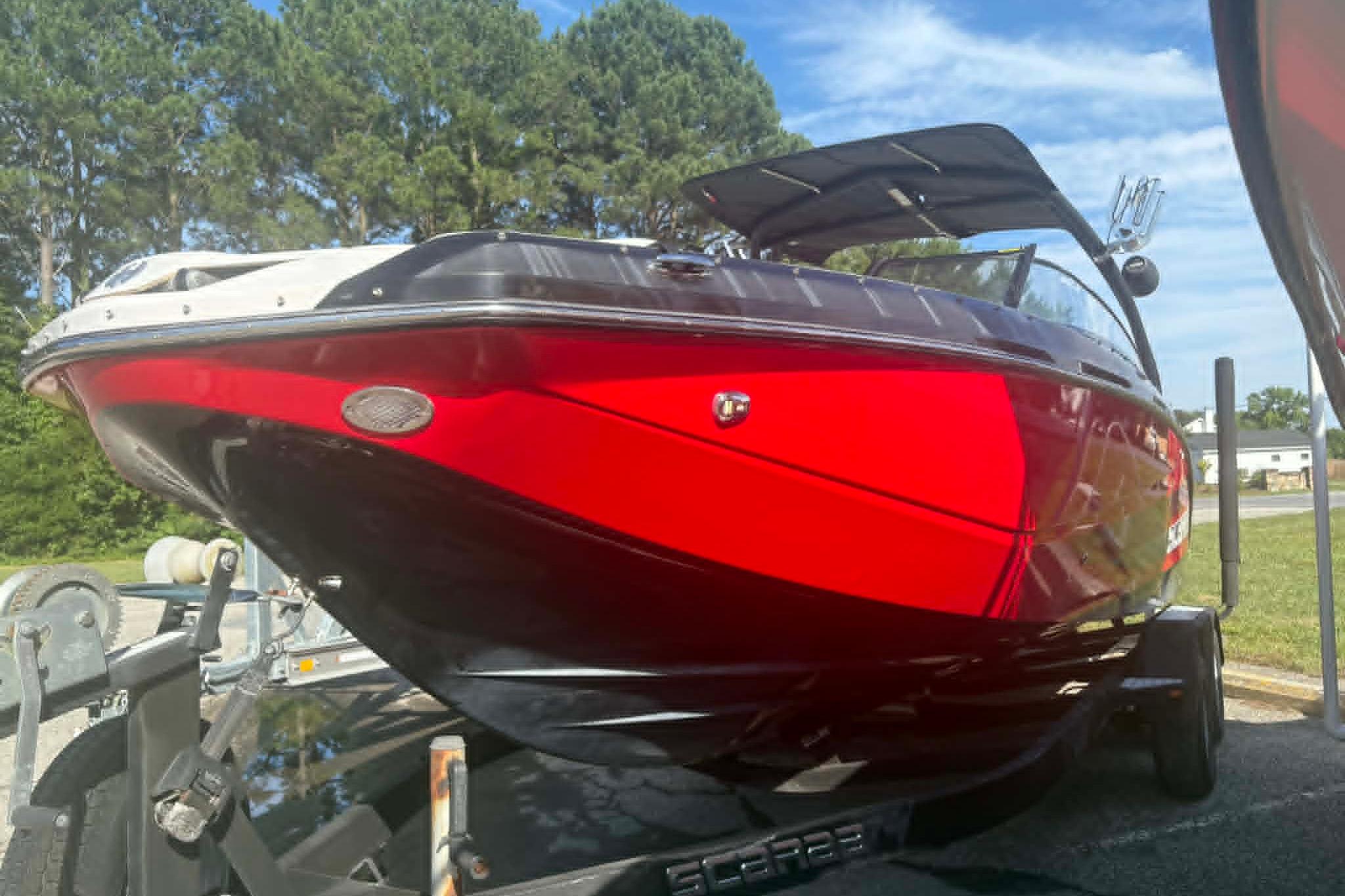 2016 Scarab 255 H.O. Impulse boat with vibrant red and black design on trailer.