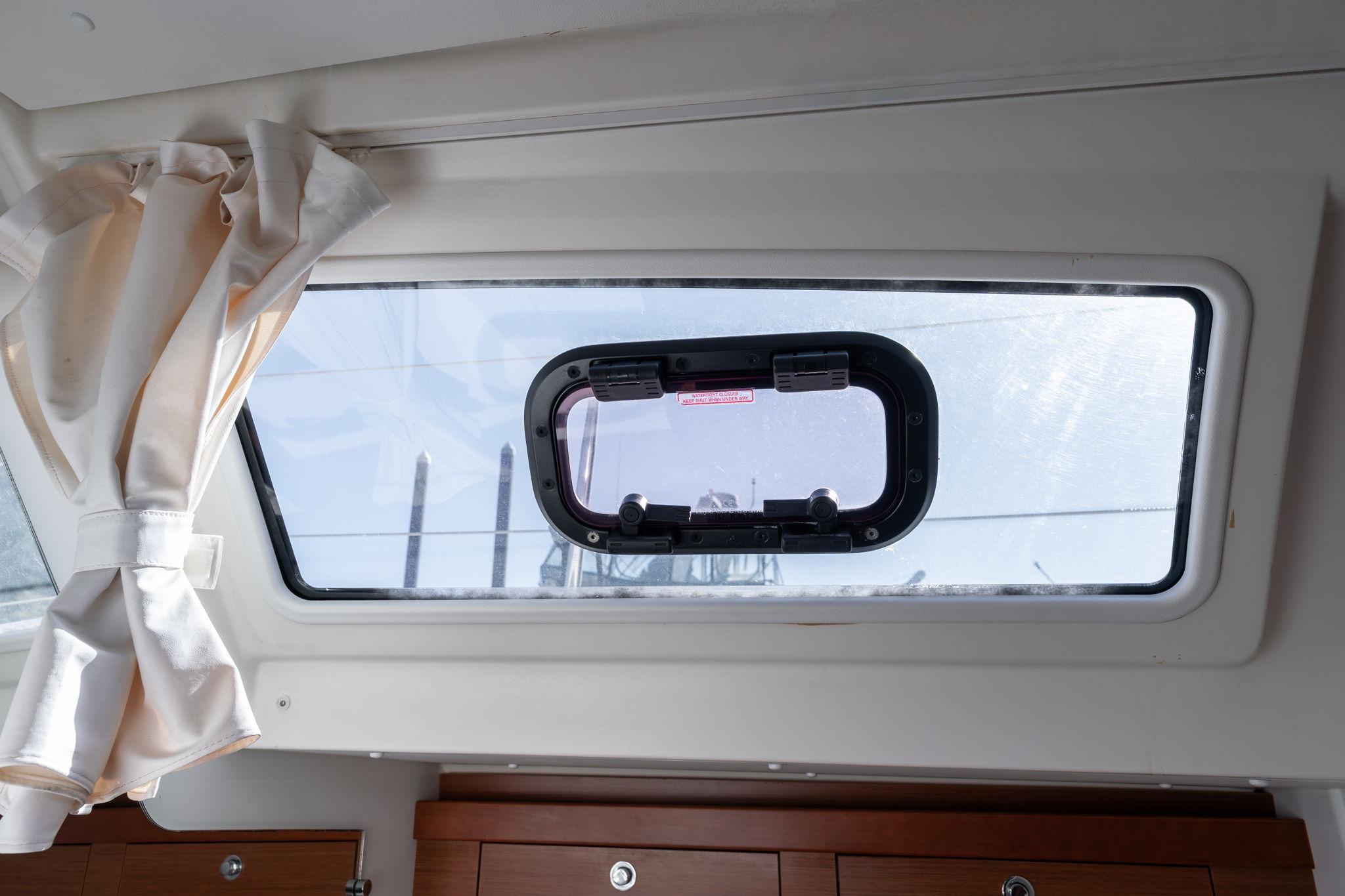 Interior view of a 2013 Beneteau Oceanis 50 yacht window with curtain.
