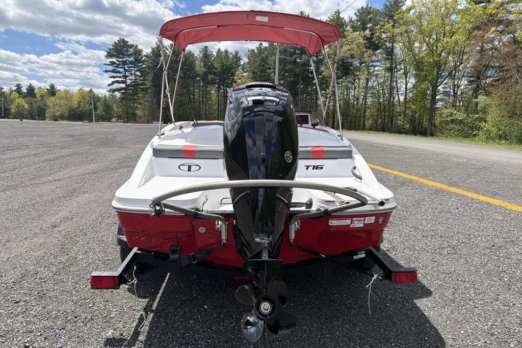 2026 Tahoe T16 boat with outboard motor on a trailer, parked in a scenic area.