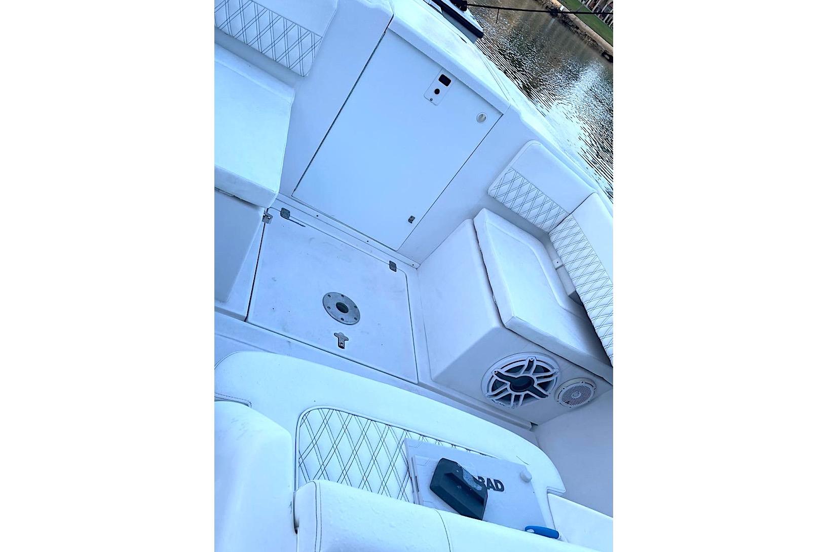 2002 Intrepid 323 Cuddy boat interior with white seating and speaker system.